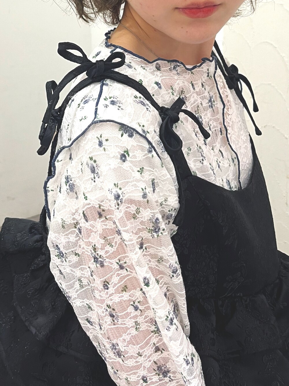 ブラック系のワンピース、ホワイト系のTシャツ/カットソー、ブラック系のサンダルを着用したレディースの春コーディネートの6枚目の写真