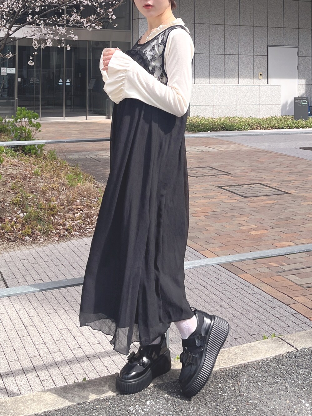 ホワイト系のTシャツ/カットソー、ブラック系のワンピース、ブラック系のスニーカーを着用したレディースの春コーディネートの3枚目の写真