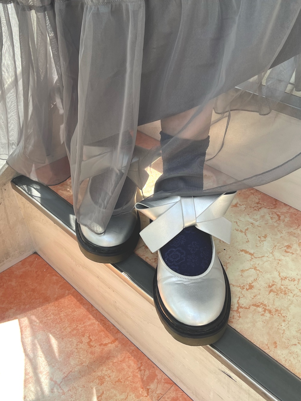 グレー系のワンピース、ピンク系のカーディガン/ボレロ、ホワイト系のTシャツ/カットソーを着用したレディースの秋コーディネートの9枚目の写真