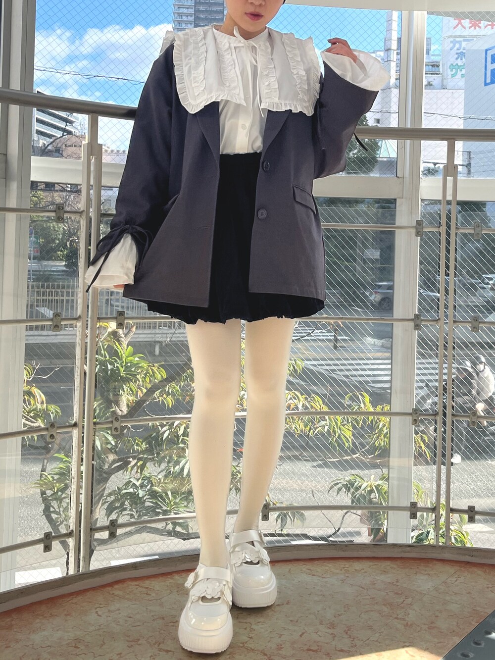 グレー系のテーラードジャケット、ホワイト系のシャツ/ブラウス、ブラック系のスカートを着用したレディースの冬コーディネートの2枚目の写真