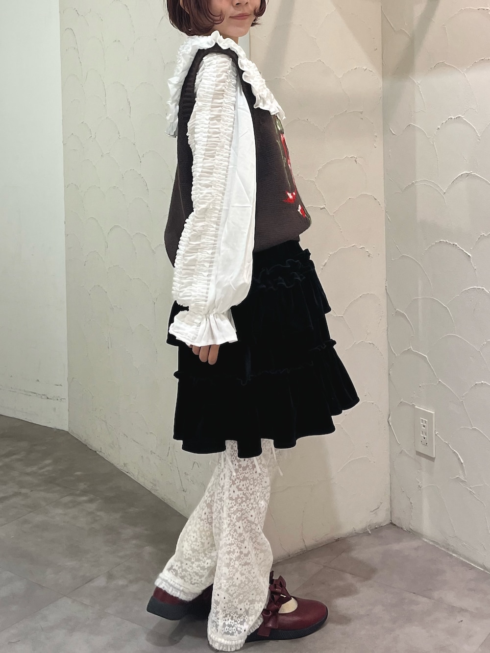 レッド系のパンプス、ブラウン系のベスト、ホワイト系のシャツ/ブラウスを着用したレディースの秋コーディネートの3枚目の写真