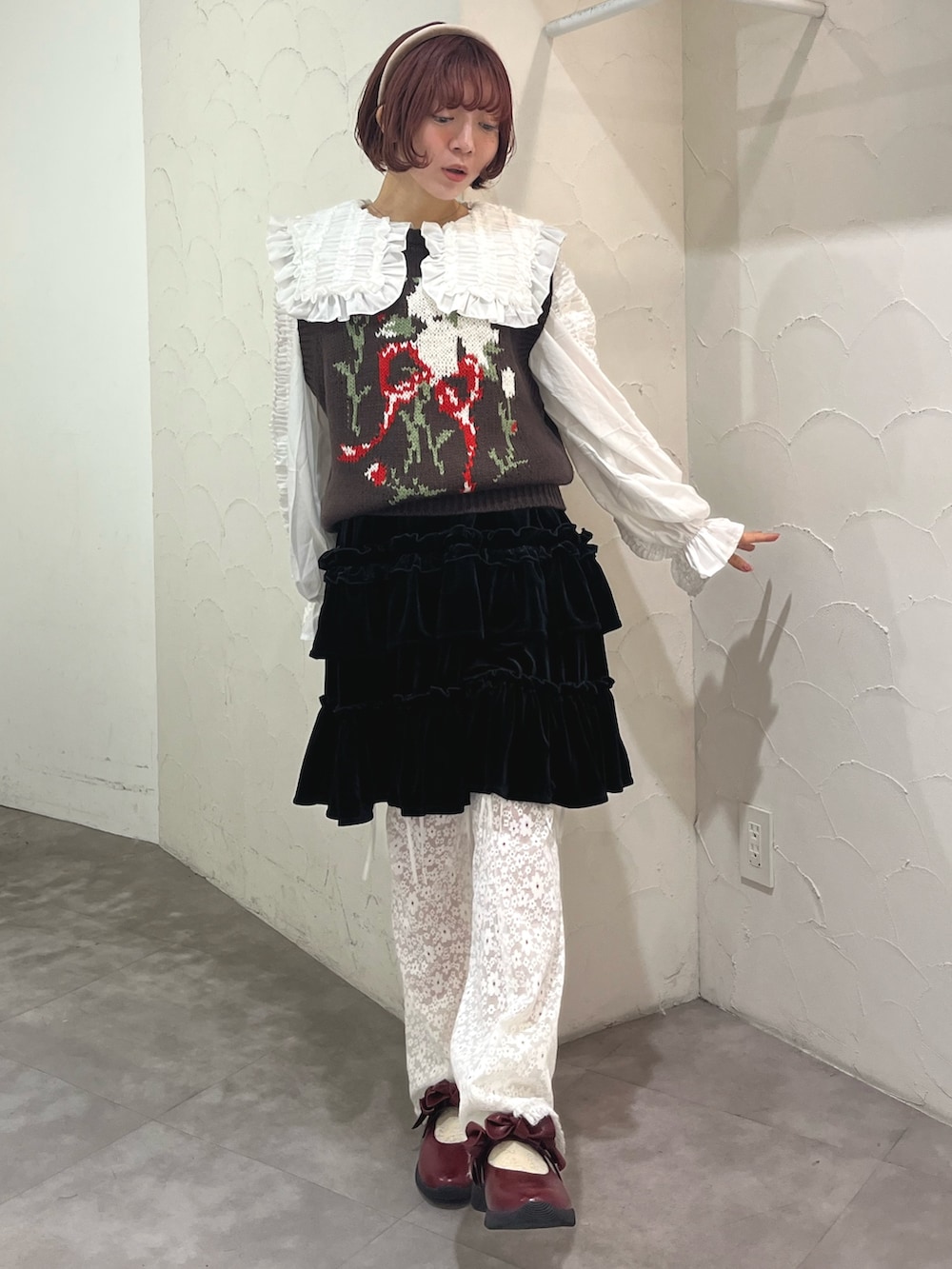 レッド系のパンプス、ブラウン系のベスト、ホワイト系のシャツ/ブラウスを着用したレディースの秋コーディネートの2枚目の写真