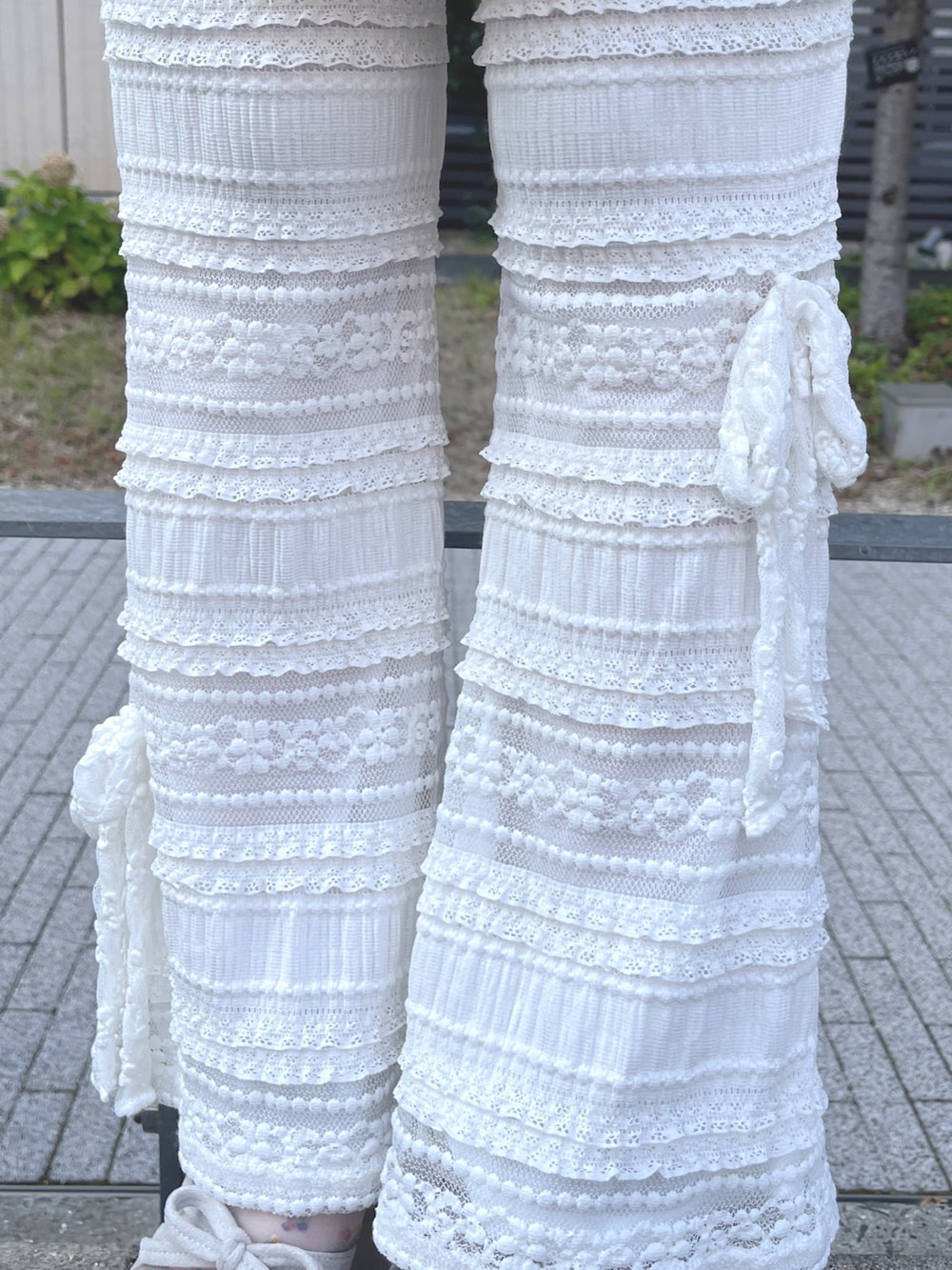 ホワイト系のチュニック、ホワイト系のその他パンツ、ベージュ系のサンダルを着用したレディースの夏コーディネートの9枚目の写真