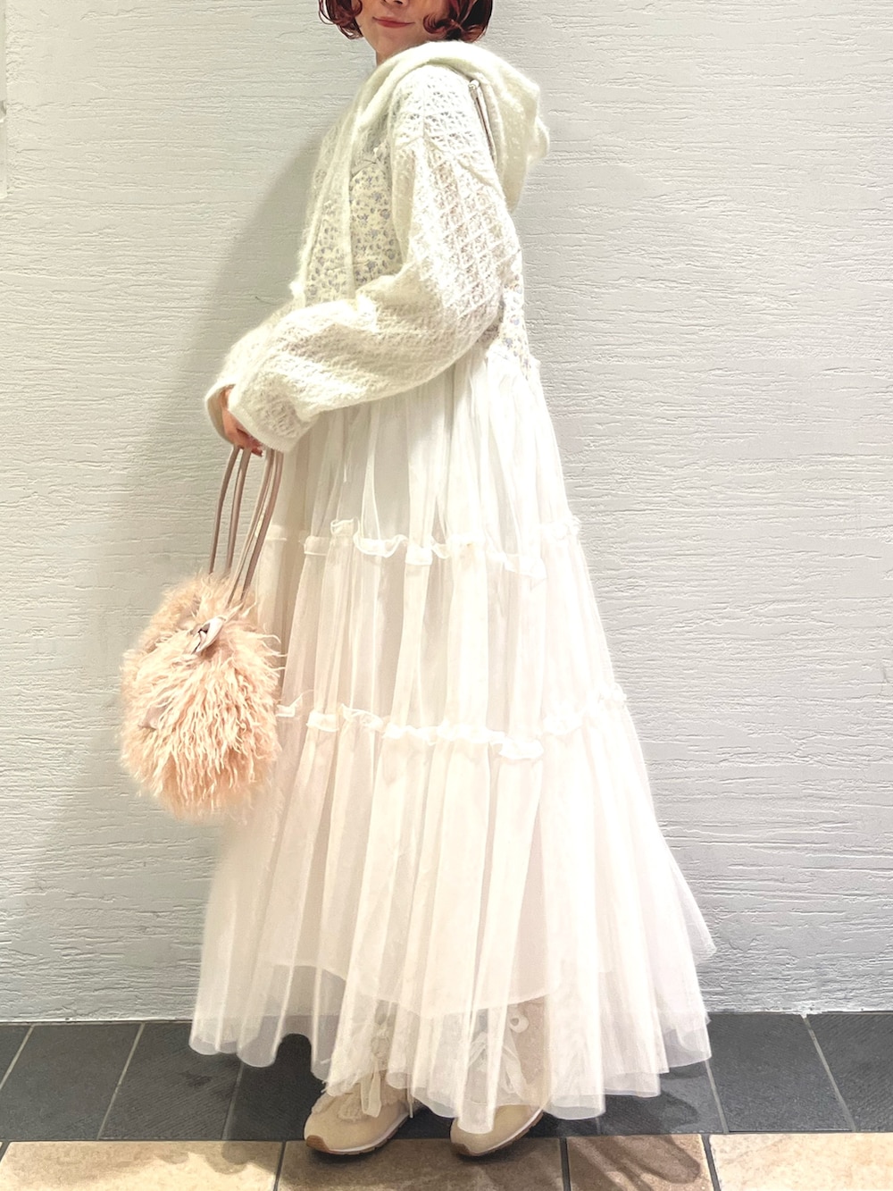 ピンク系のボストンバッグ、ホワイト系のニット/セーター、ホワイト系のワンピースを着用したレディースの秋コーディネートの3枚目の写真