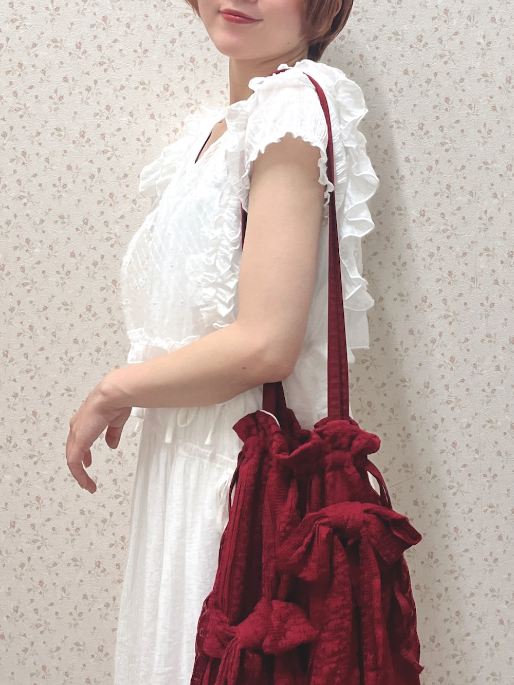 ホワイト系のワンピース、レッド系のトートバッグ、ホワイト系のスニーカーを着用したレディースの春コーディネートの6枚目の写真