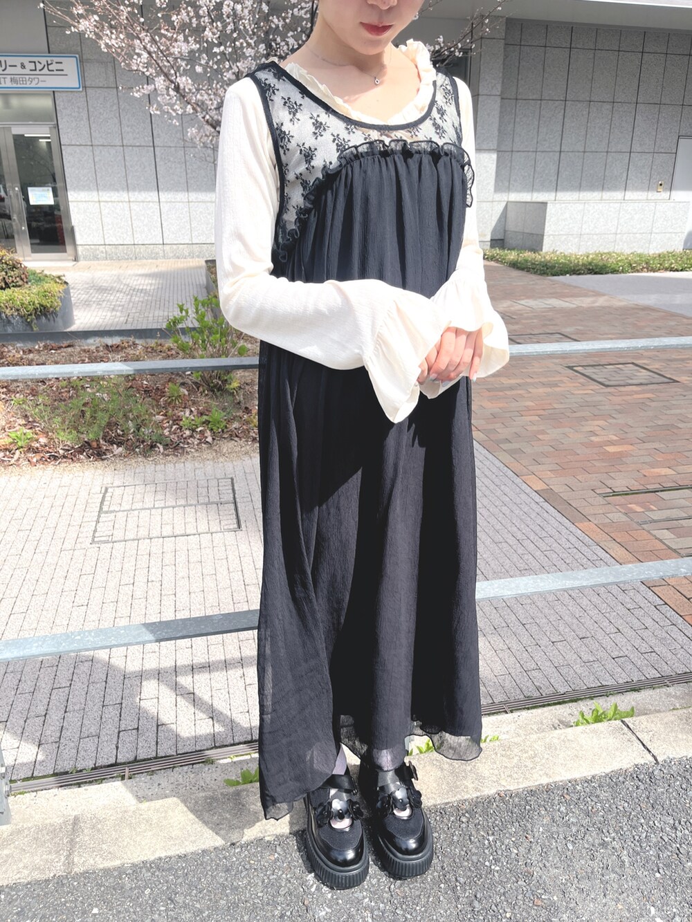 ホワイト系のTシャツ/カットソー、ブラック系のワンピース、ブラック系のスニーカーを着用したレディースの春コーディネートの8枚目の写真