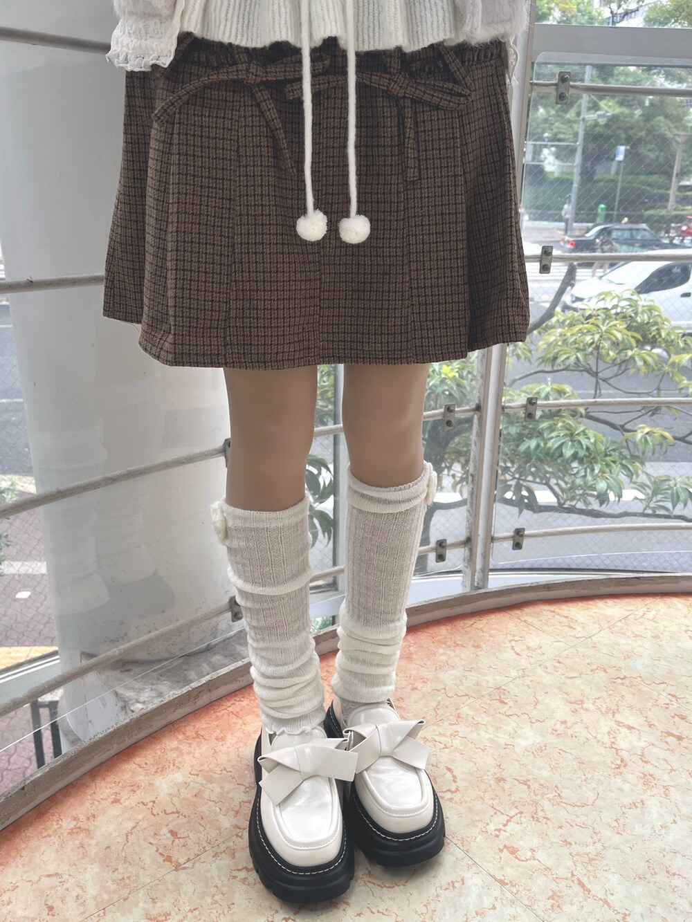 ホワイト系のニット/セーター、ホワイト系のダッフルコート、その他のスカートを着用したレディースの秋コーディネートの9枚目の写真