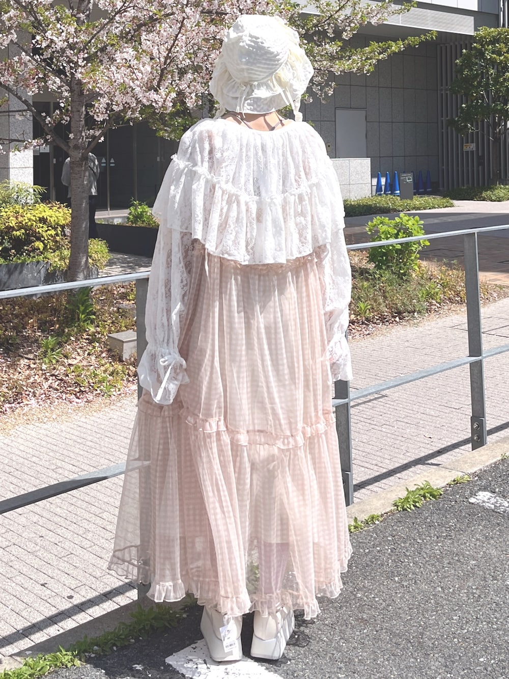 ベージュ系のワンピース、ホワイト系のカーディガン/ボレロ、ホワイト系のTシャツ/カットソーを着用したレディースの春コーディネートの3枚目の写真