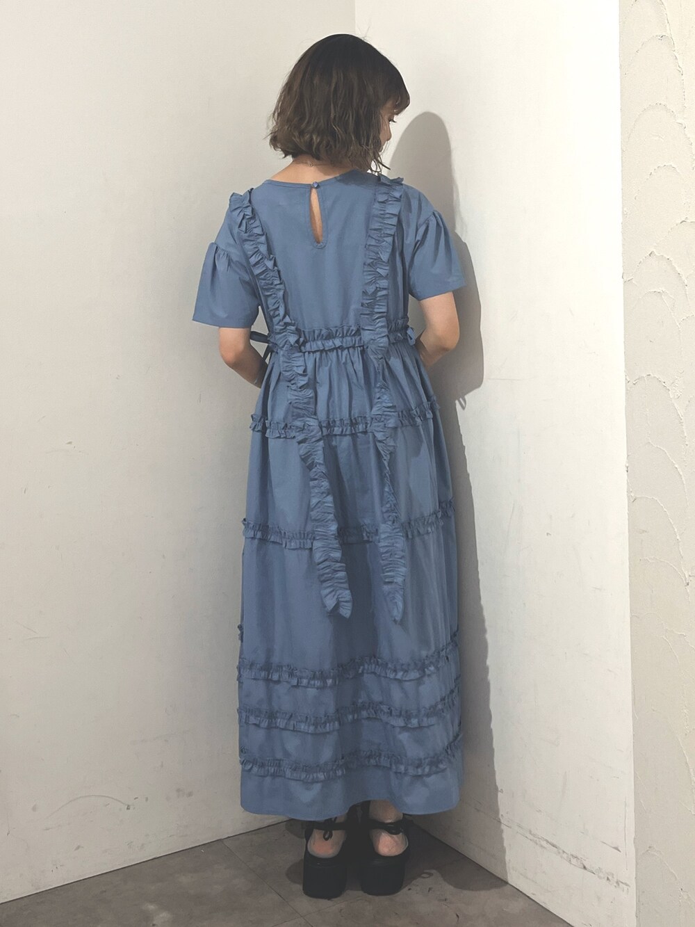 ホワイト系のトートバッグ、ブルー系のワンピース、ブラック系のサンダルを着用したレディースの夏コーディネートの6枚目の写真