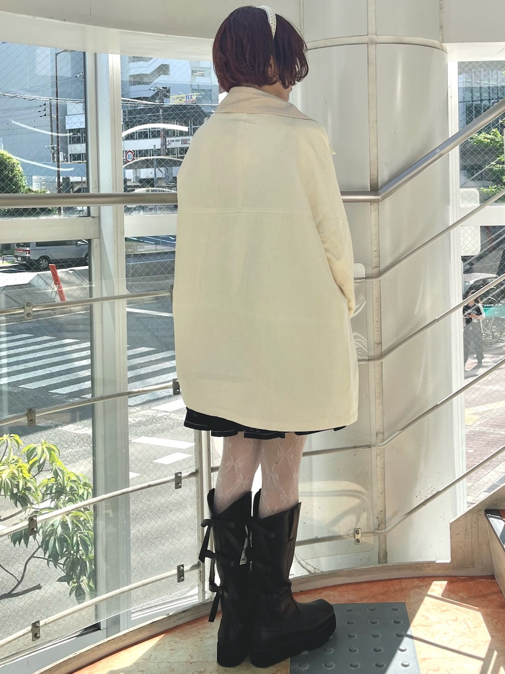 ブラック系のチュニック、イエロー系のTシャツ/カットソー、ホワイト系のブルゾンを着用したレディースの秋コーディネートの4枚目の写真