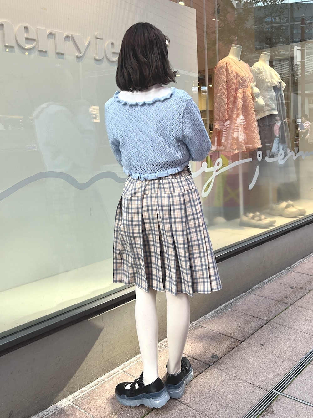 ベージュ系のスカート、ブルー系のカーディガン/ボレロ、ホワイト系のTシャツ/カットソーを着用したレディースの春コーディネートの4枚目の写真