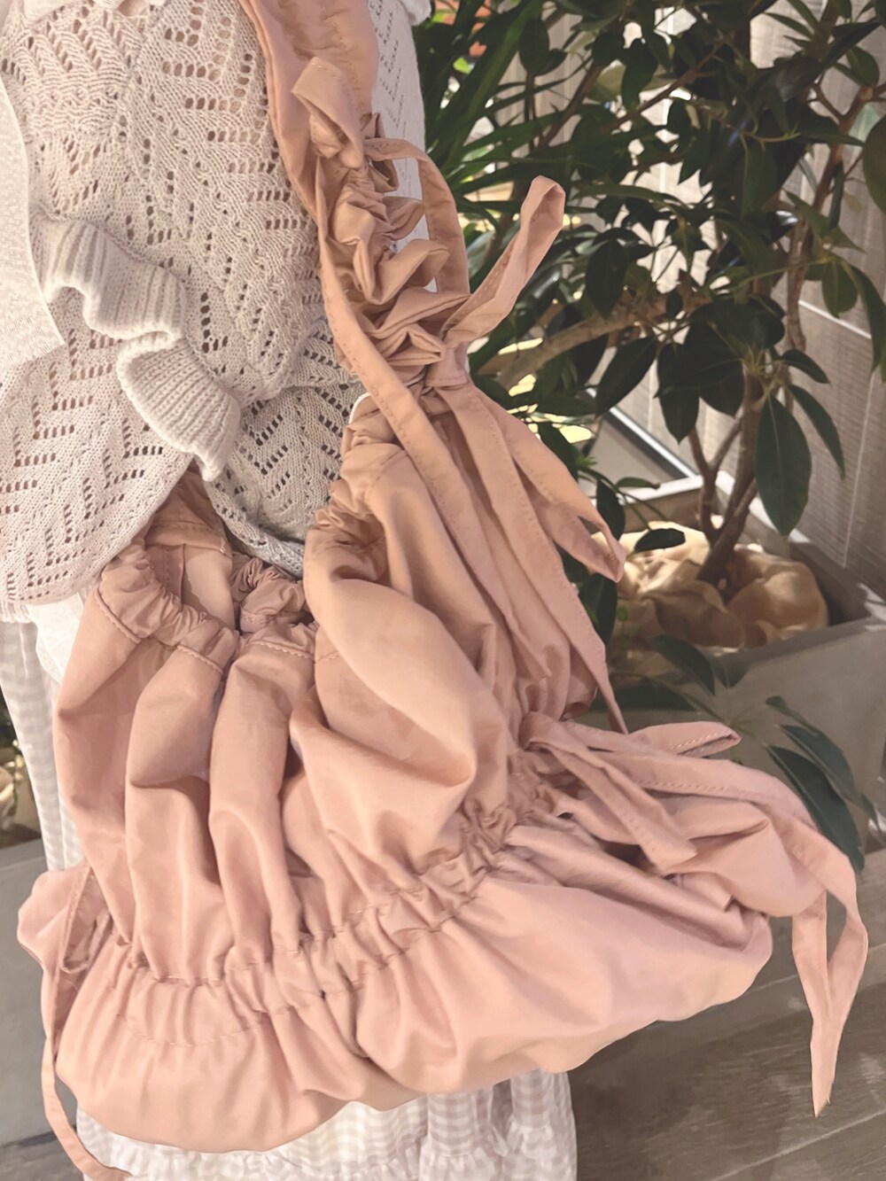 グレー系のカーディガン/ボレロ、ピンク系のニット/セーター、ベージュ系のワンピースを着用したレディースの春コーディネートの9枚目の写真