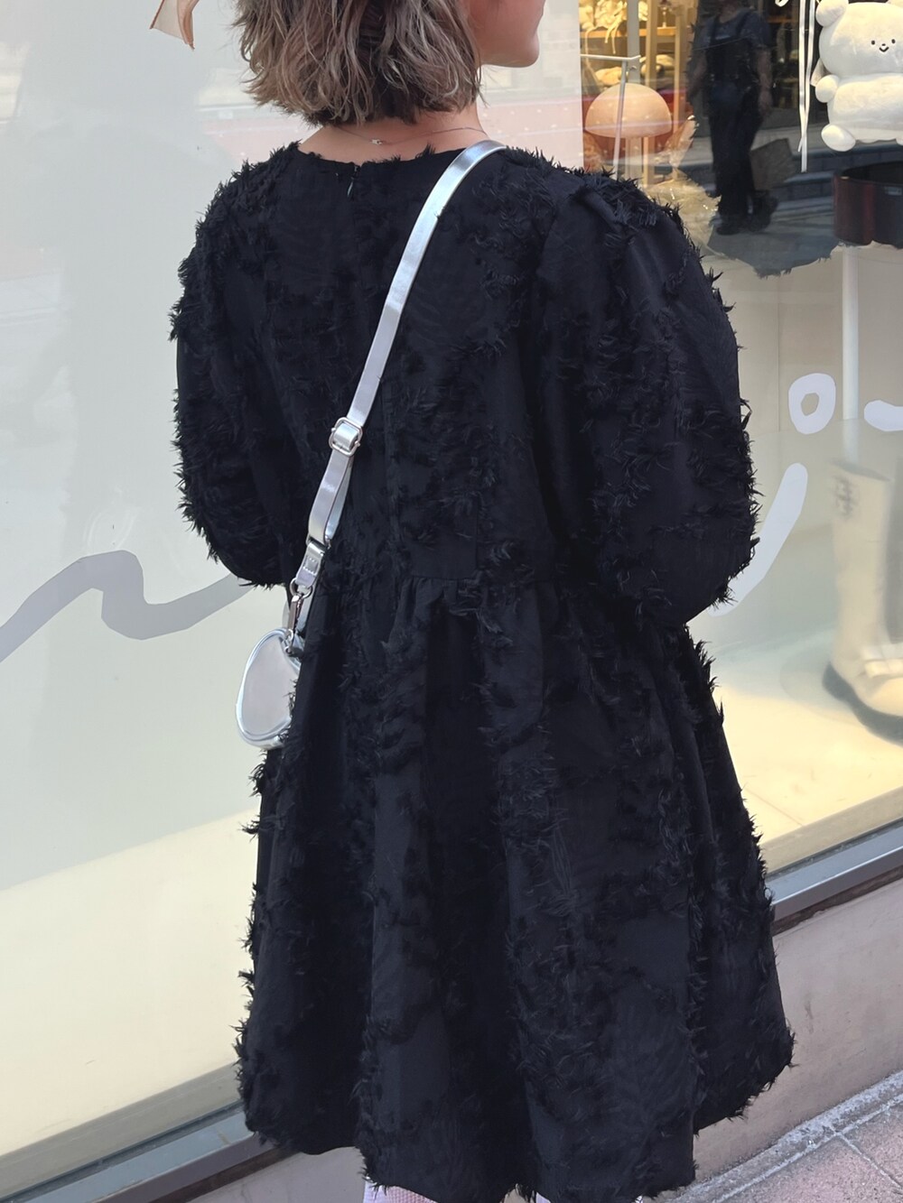 シルバー系のバレエシューズ、ブラック系のワンピース、シルバー系のショルダーバッグを着用したレディースの秋コーディネートの7枚目の写真