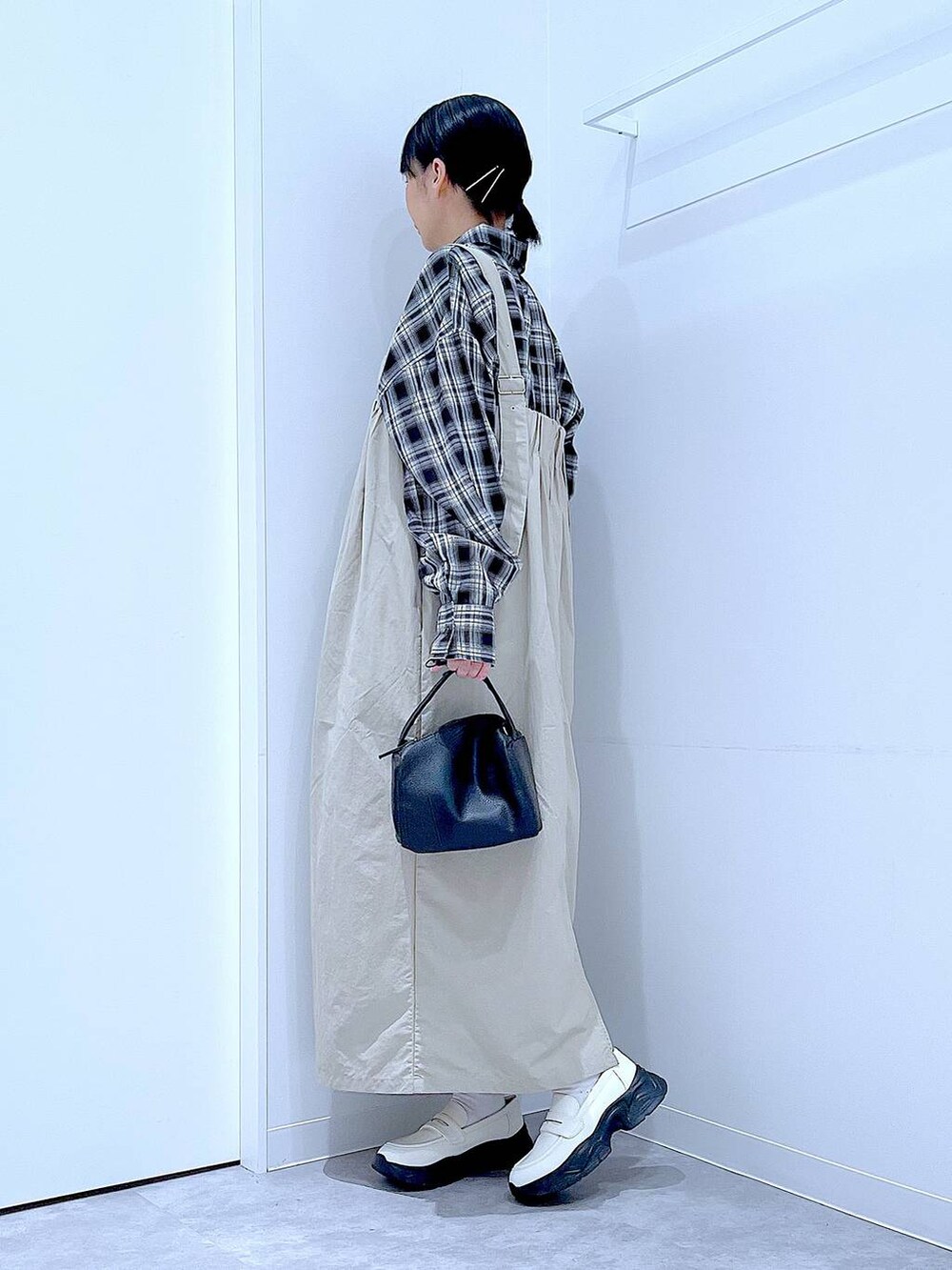 ホワイト系のローファー、ブラック系のショルダーバッグ、グレー系のワンピースを着用したレディースの秋コーディネートの3枚目の写真