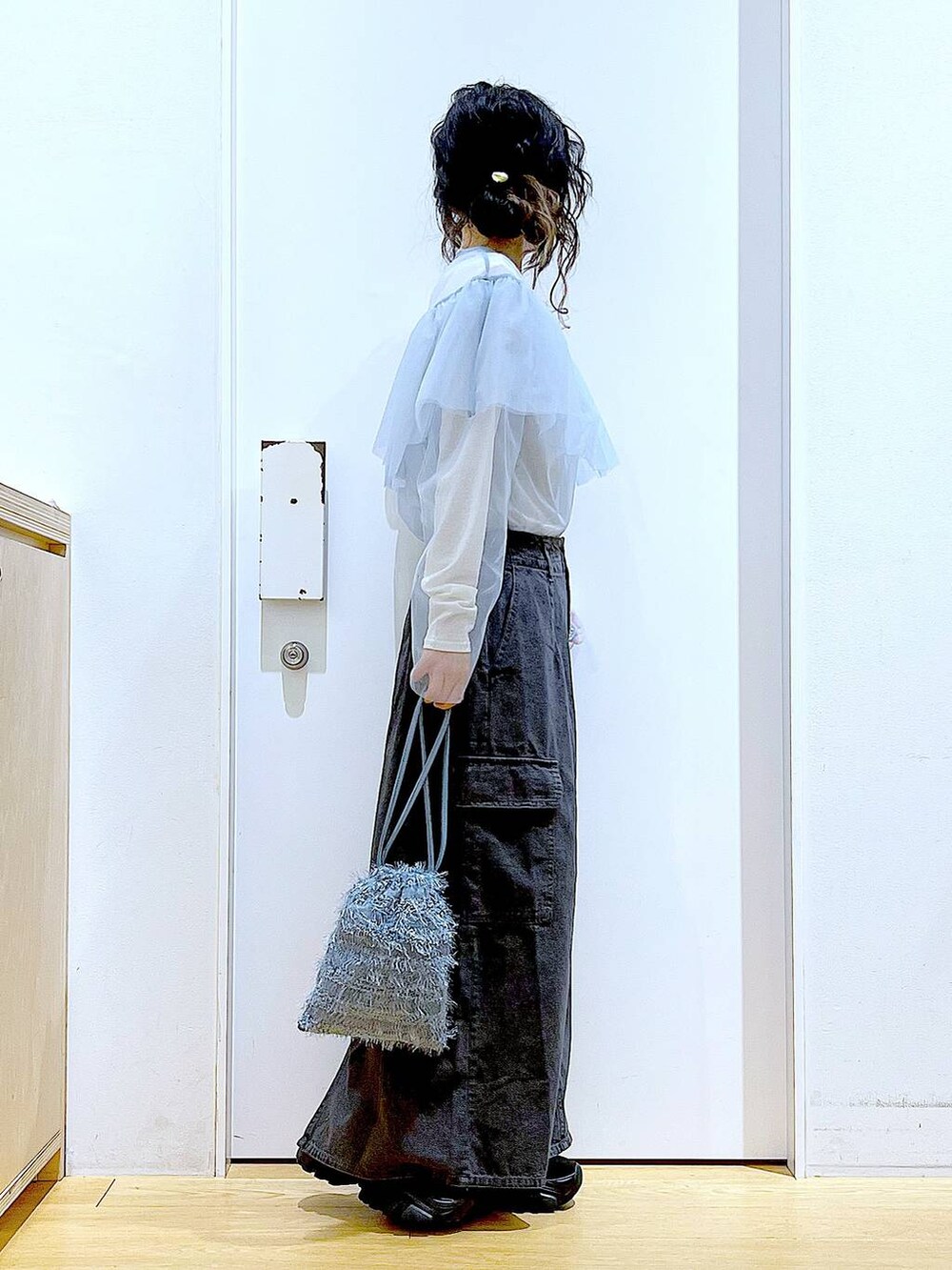 グレー系のデニムスカート、ブラック系のスニーカー、ブルー系のその他トップスを着用したレディースの春コーディネートの4枚目の写真