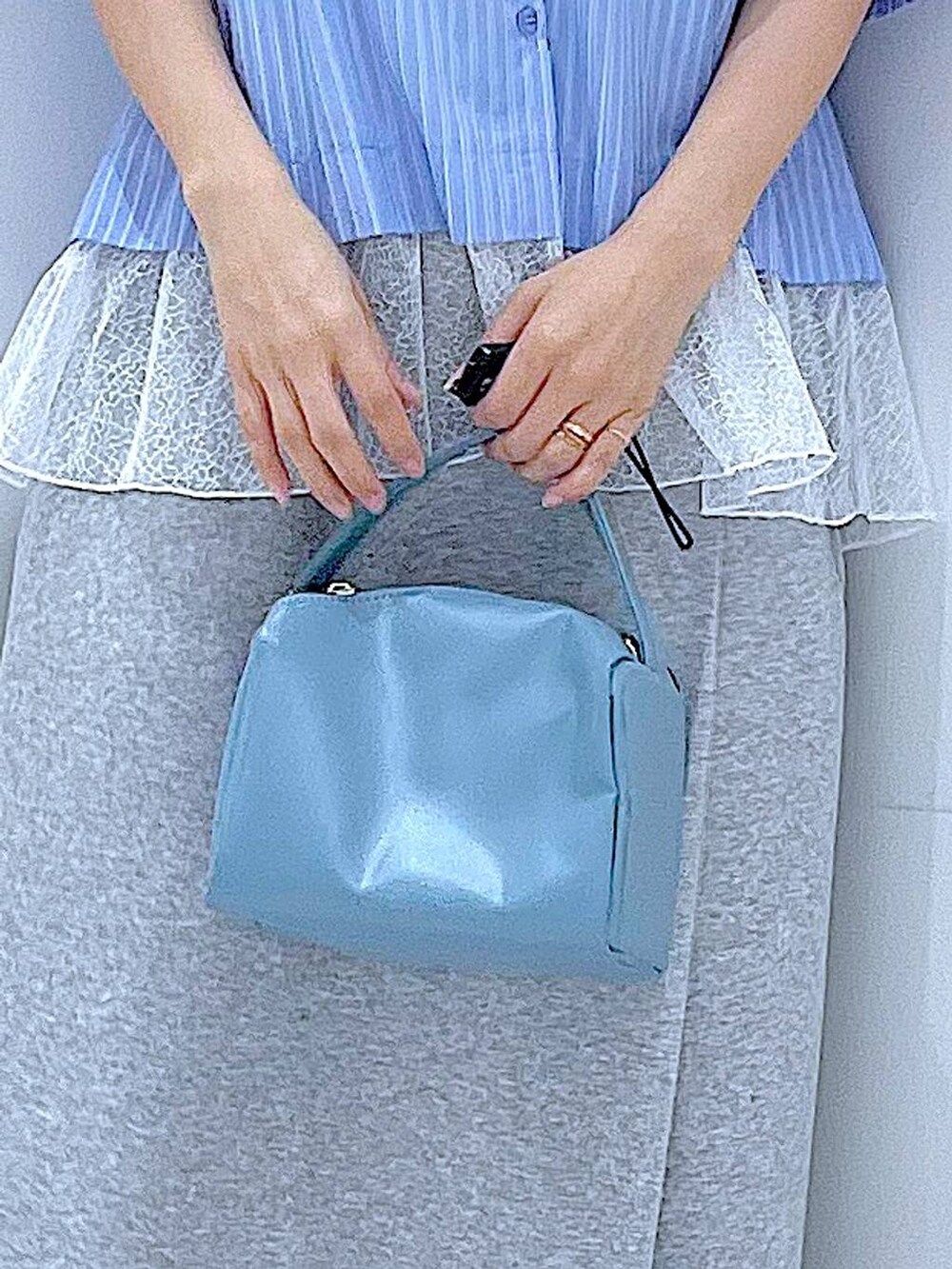 ブルー系のショルダーバッグ、ブラック系のスニーカー、グレー系のスカートを着用したレディースの春コーディネートの9枚目の写真