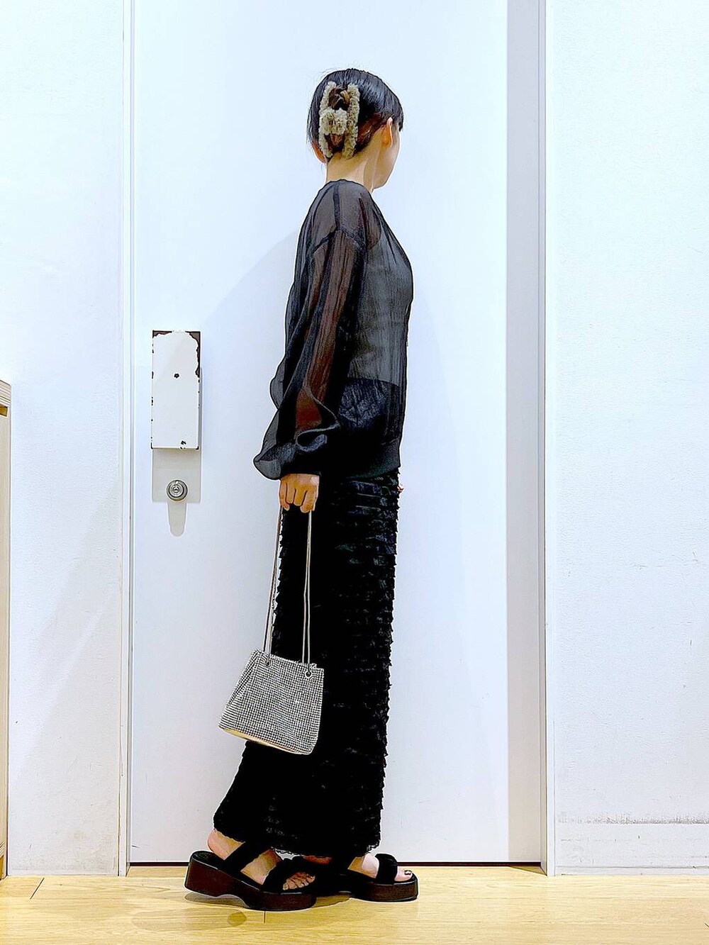 ブラック系のサンダル、ブラック系のブルゾン、ホワイト系のニット/セーターを着用したレディースの夏コーディネートの4枚目の写真