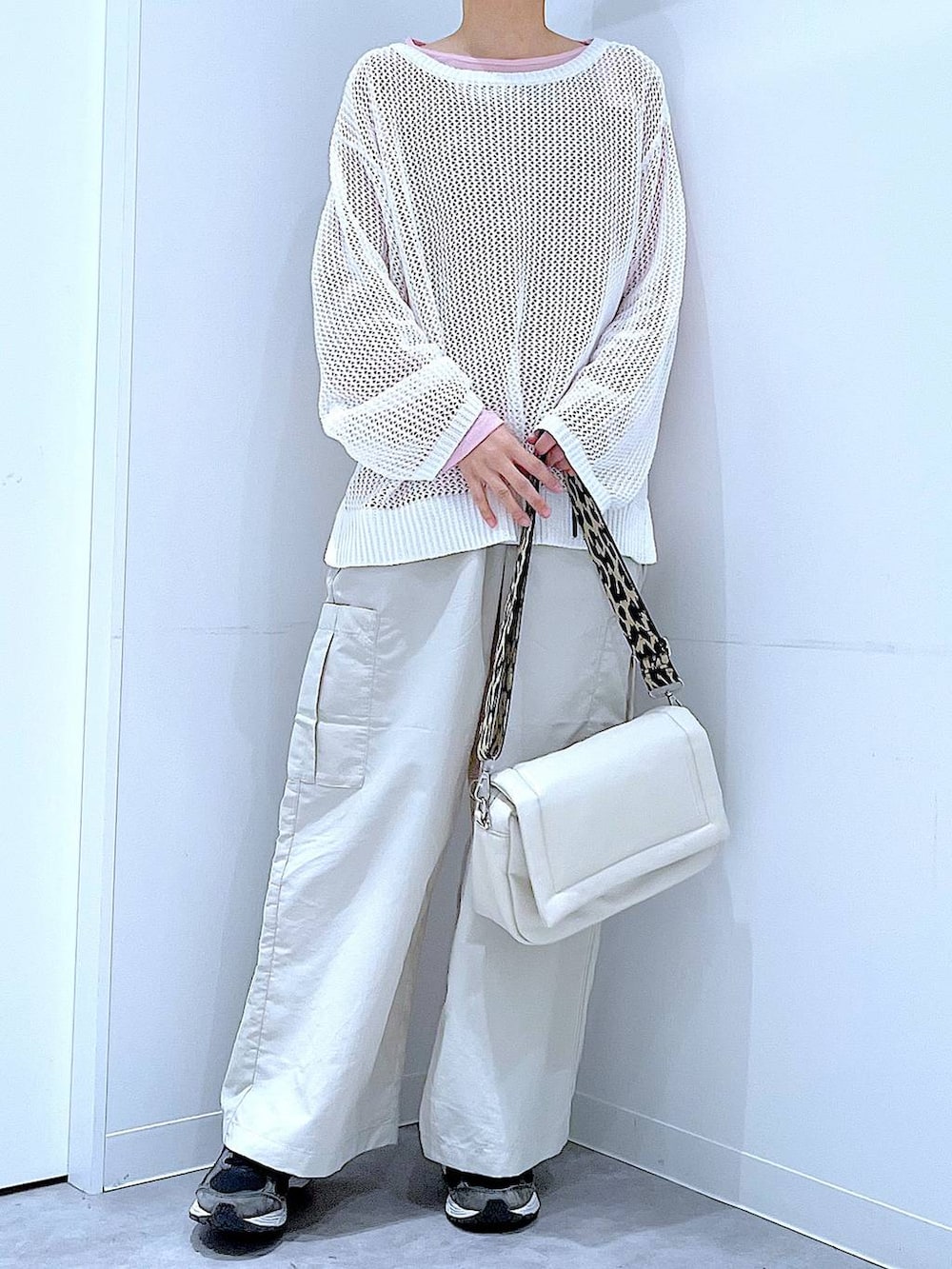 ピンク系のTシャツ/カットソー、ホワイト系のショルダーバッグ、ホワイト系のニット/セーターを着用したレディースの春コーディネートの6枚目の写真