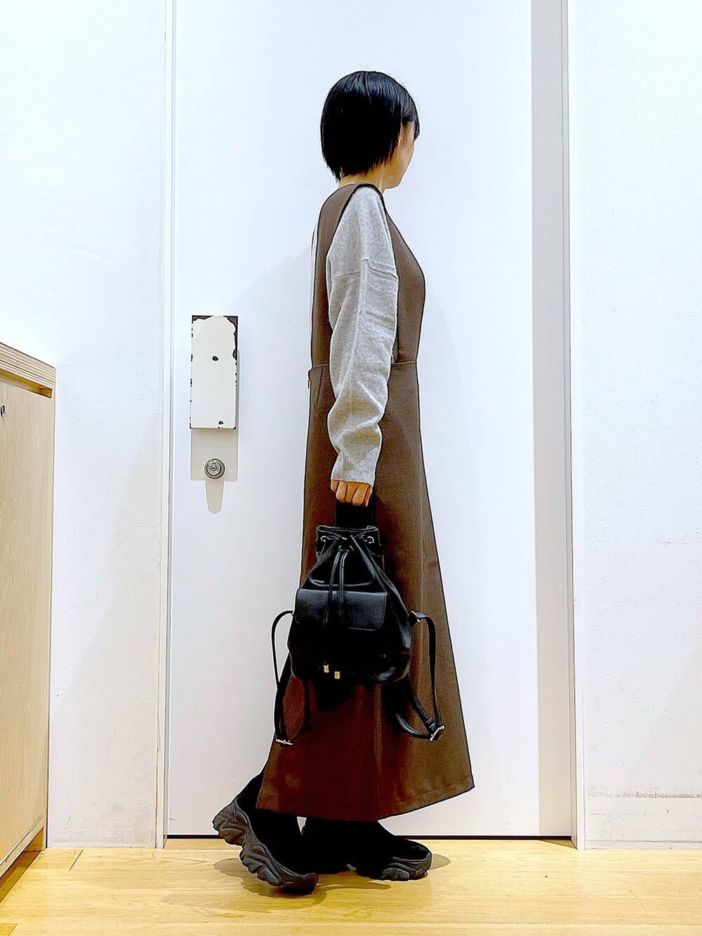 グレー系のニット/セーター、ブラック系のバックパック/リュック、ブラック系のブーツを着用したレディースの冬コーディネートの4枚目の写真