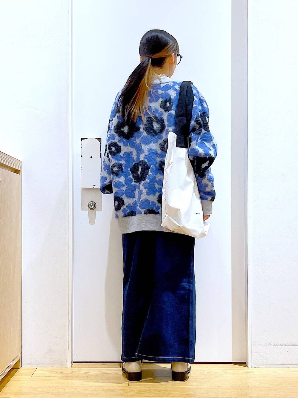 ブルー系のジャンパースカート、ホワイト系のTシャツ/カットソー、ベージュ系のブーツを着用したレディースの冬コーディネートの5枚目の写真