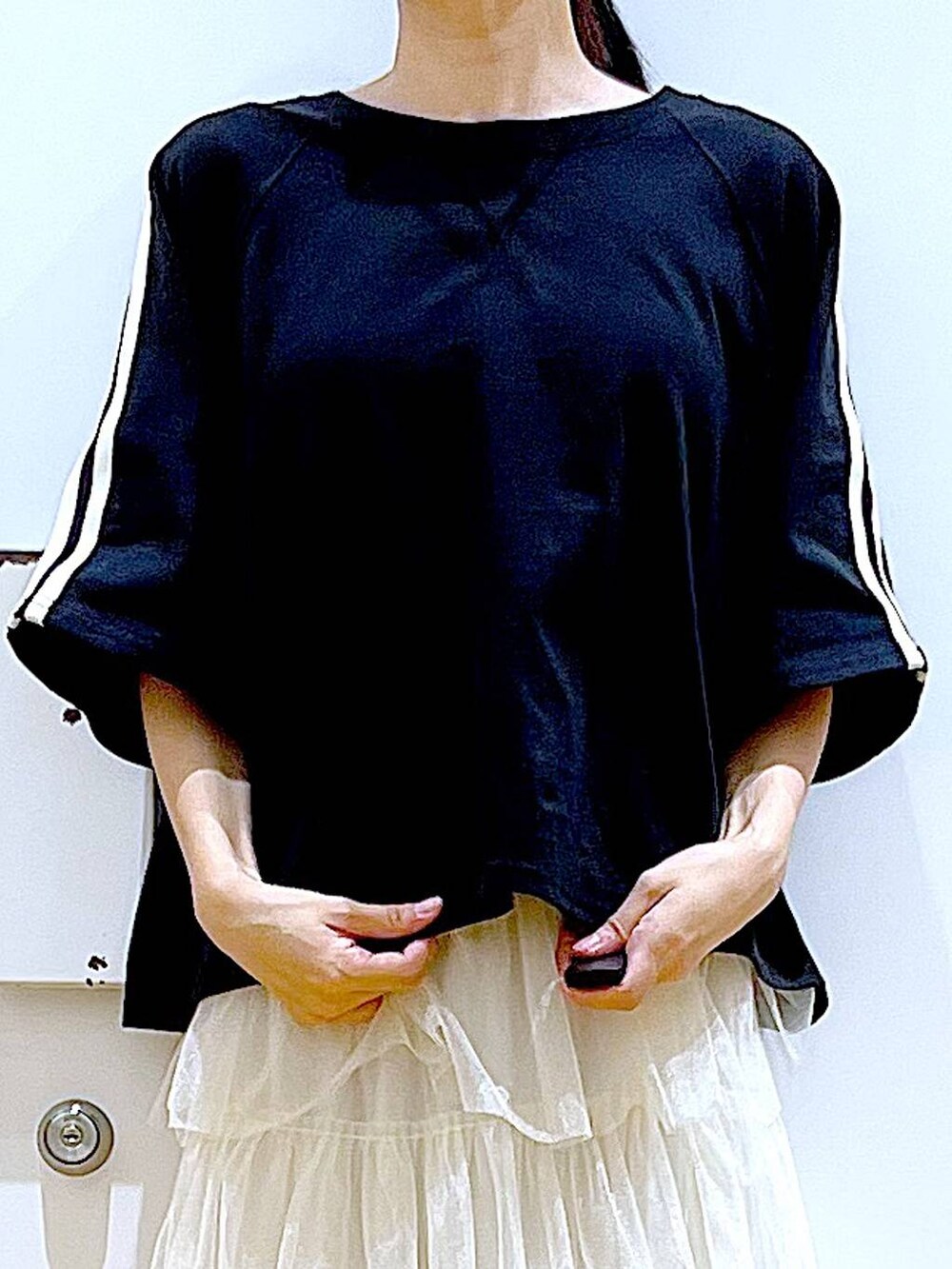 ブラック系のサンダル、ブラック系のショルダーバッグ、ベージュ系のスカートを着用したレディースの夏コーディネートの7枚目の写真