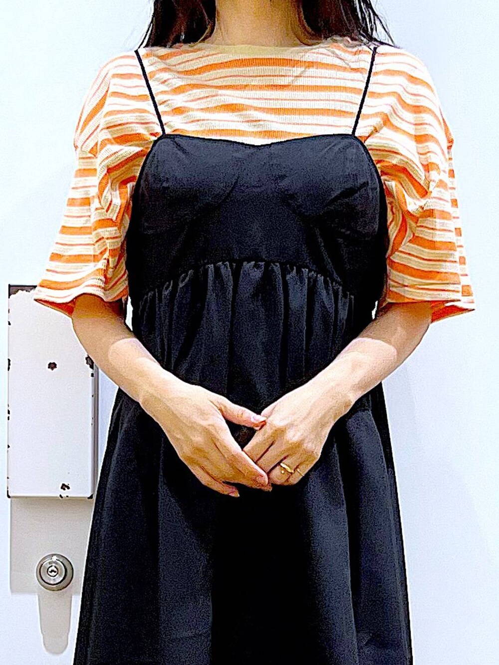 ブラック系のサンダル、オレンジ系のTシャツ/カットソー、ホワイト系のトートバッグを着用したレディースの夏コーディネートの7枚目の写真