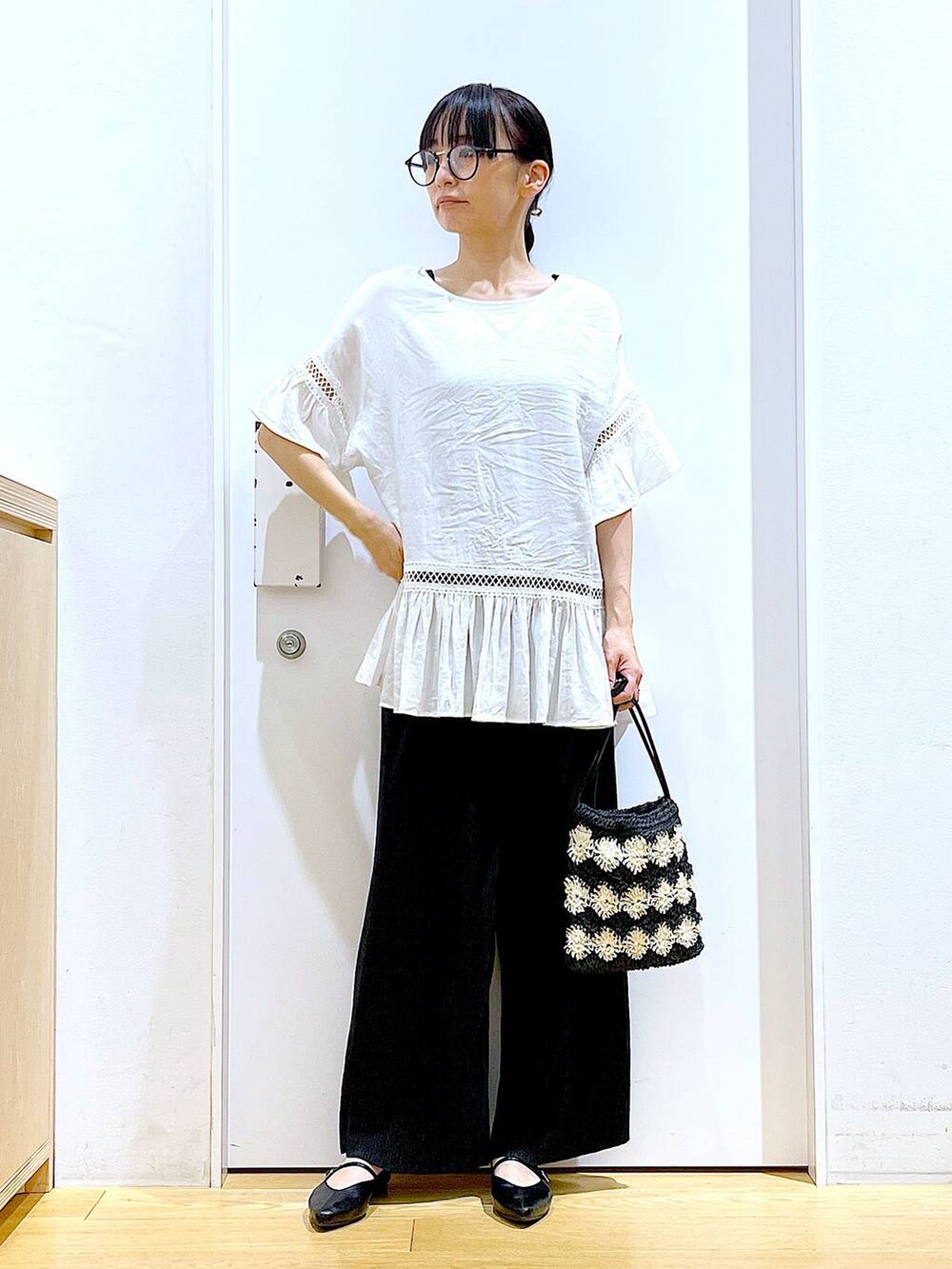 ホワイト系のチュニック、ブラック系のその他パンツ、ブラック系のパンプスを着用したレディースの夏コーディネートの2枚目の写真