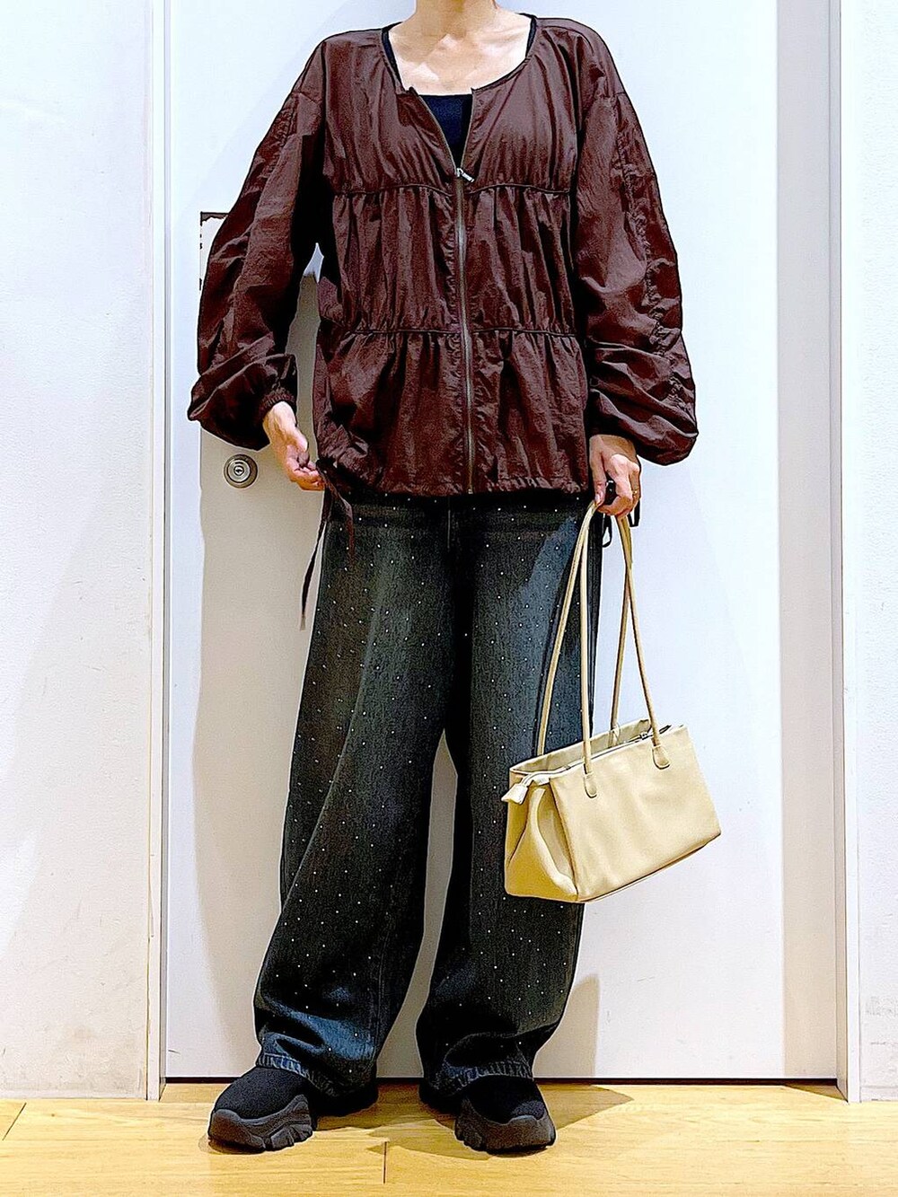 ブラック系のブーツ、ベージュ系のトートバッグ、ブラウン系のブルゾンを着用したレディースの冬コーディネートの6枚目の写真