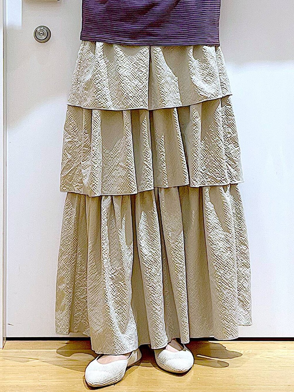 ブラウン系のTシャツ/カットソー、ベージュ系のスカート、ブラック系のバックパック/リュックを着用したレディースの春コーディネートの8枚目の写真