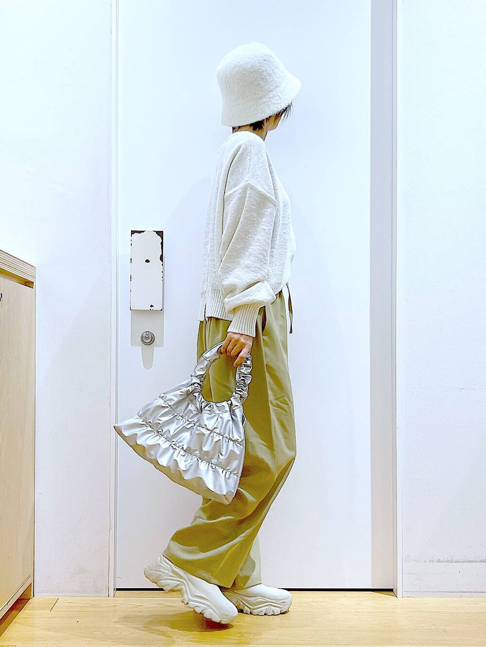 ベージュ系のブーツ、イエロー系のその他パンツ、シルバー系のショルダーバッグを着用したレディースの冬コーディネートの4枚目の写真