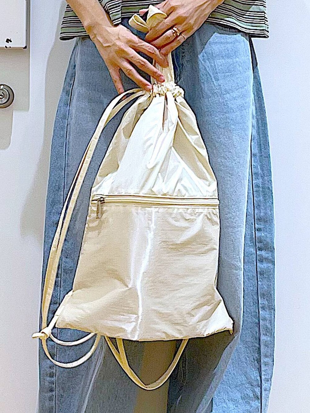 ホワイト系のバックパック/リュック、ホワイト系のサンダル、ブルー系のデニムパンツを着用したレディースの夏コーディネートの9枚目の写真