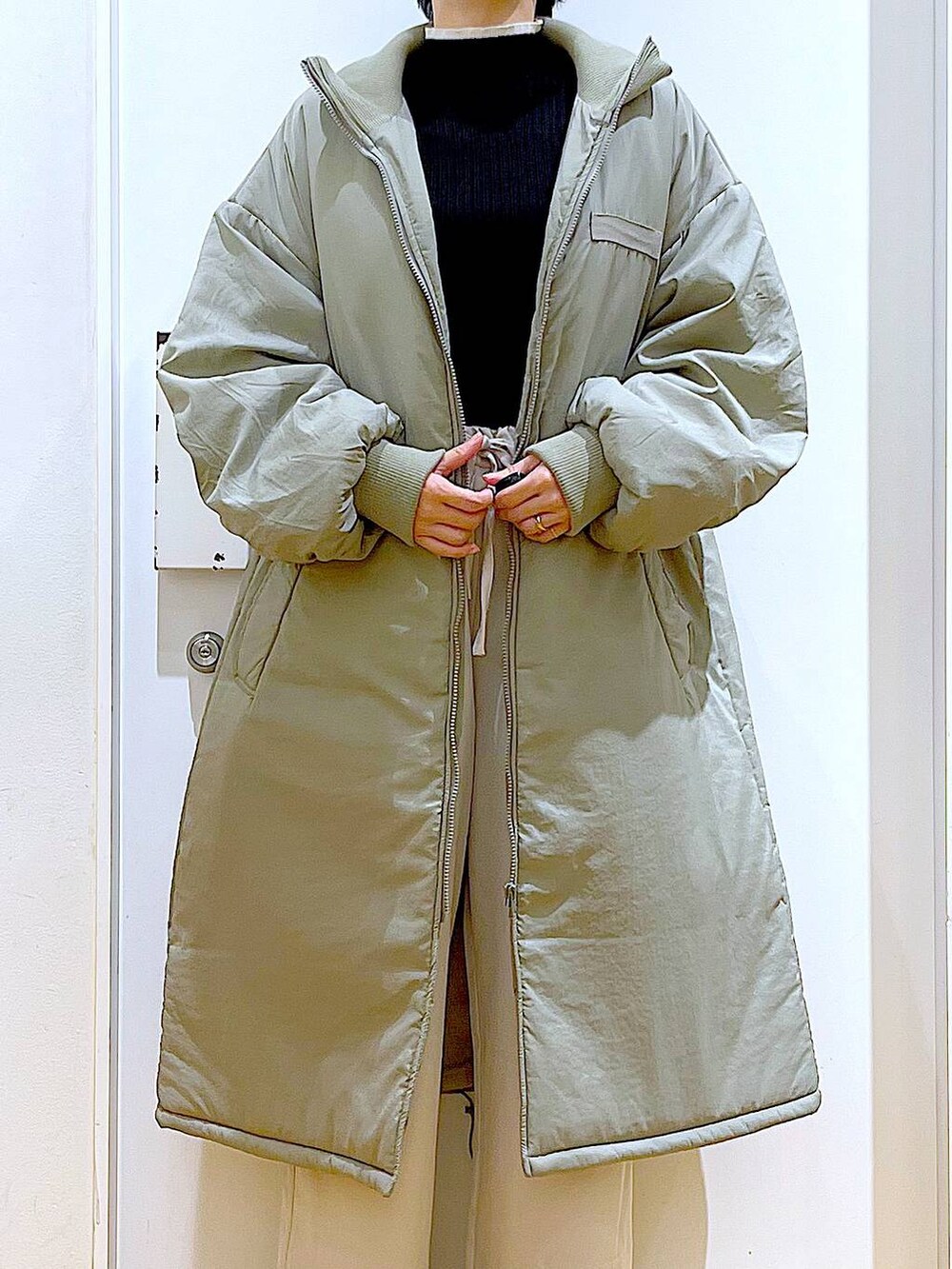 ブラック系のニット/セーター、ベージュ系のショルダーバッグ、ブラック系のブーツを着用したレディースの冬コーディネートの7枚目の写真