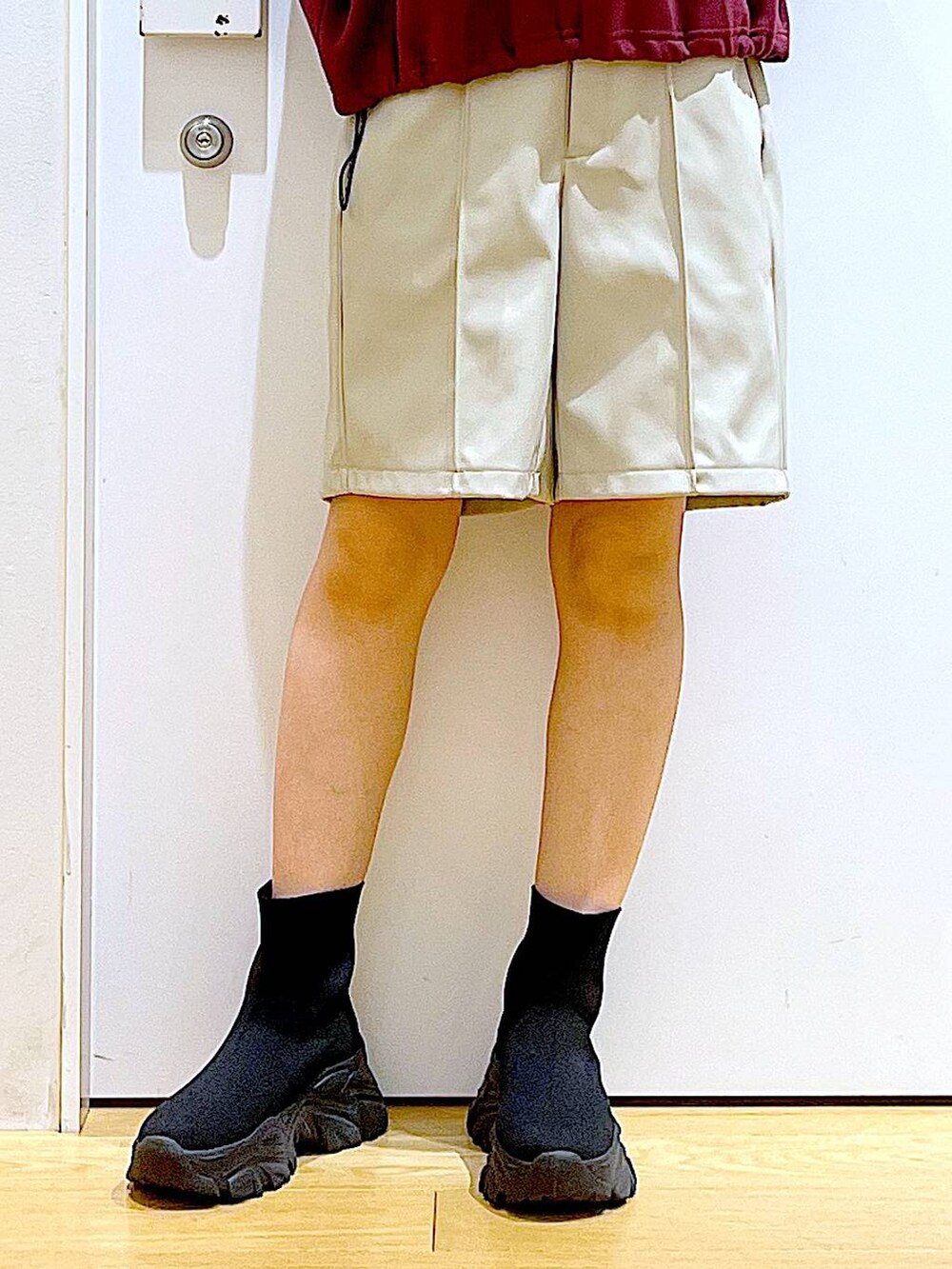 ホワイト系のショルダーバッグ、ブラック系のブーツ、レッド系のスウェットを着用したレディースの冬コーディネートの8枚目の写真