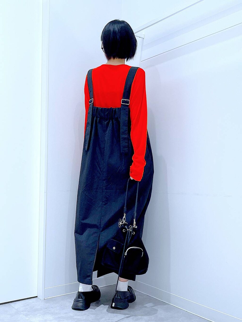 オレンジ系のTシャツ/カットソー、ブラック系のローファー、ブラック系のショルダーバッグを着用したレディースの秋コーディネートの5枚目の写真