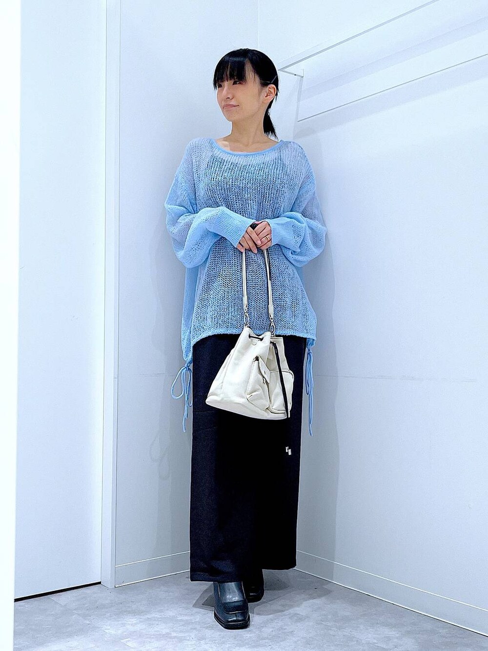 ブラック系のその他パンツ、ホワイト系のショルダーバッグ、ブラック系のブーツを着用したレディースの冬コーディネートの2枚目の写真