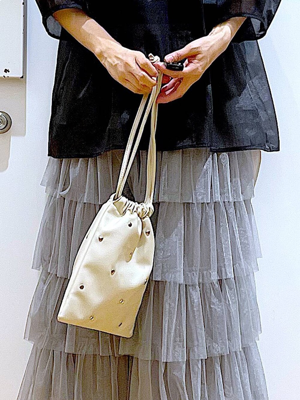 ホワイト系のサンダル、ブラック系のニット/セーター、ホワイト系のショルダーバッグを着用したレディースの夏コーディネートの9枚目の写真