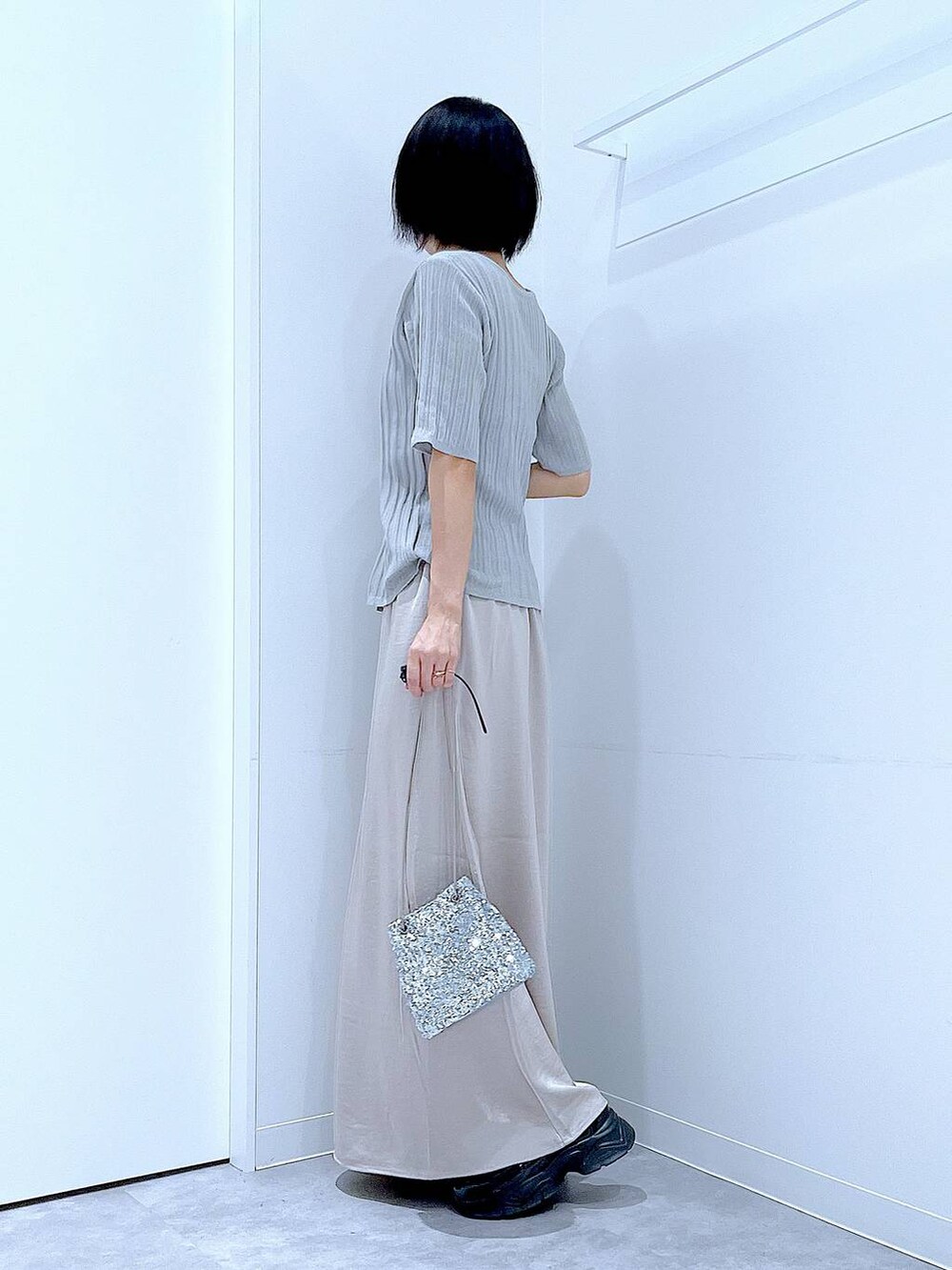 シルバー系のショルダーバッグ、ブラック系のローファー、グレー系のニット/セーターを着用したレディースの秋コーディネートの3枚目の写真