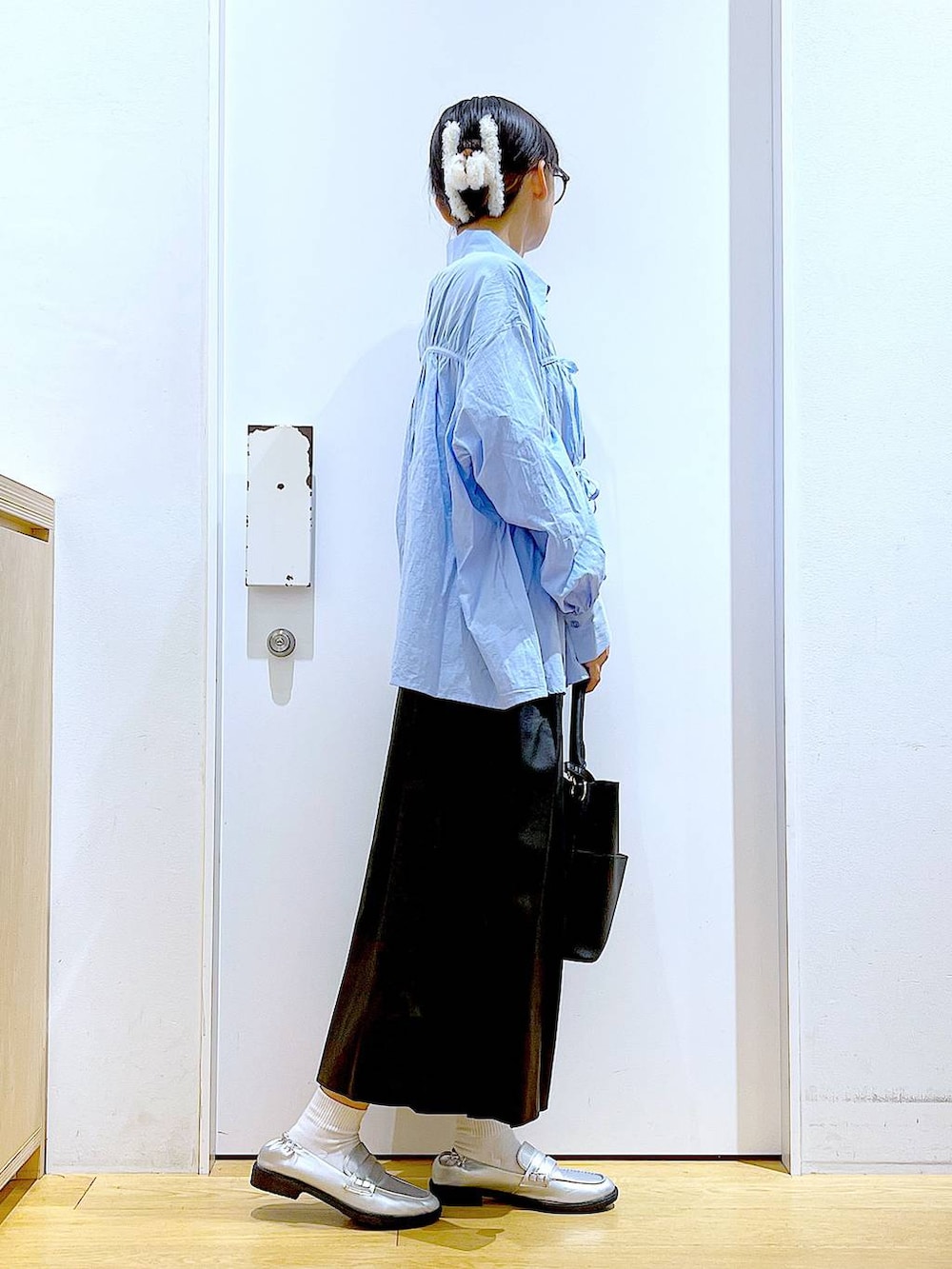 シルバー系のローファー、ブラック系のショルダーバッグ、ブルー系のシャツ/ブラウスを着用したレディースの秋コーディネートの4枚目の写真