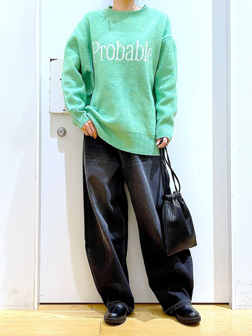 ブラック系のショルダーバッグ、ブラック系のブーツ、ブラック系のデニムパンツを着用したレディースの冬コーディネートの6枚目の写真