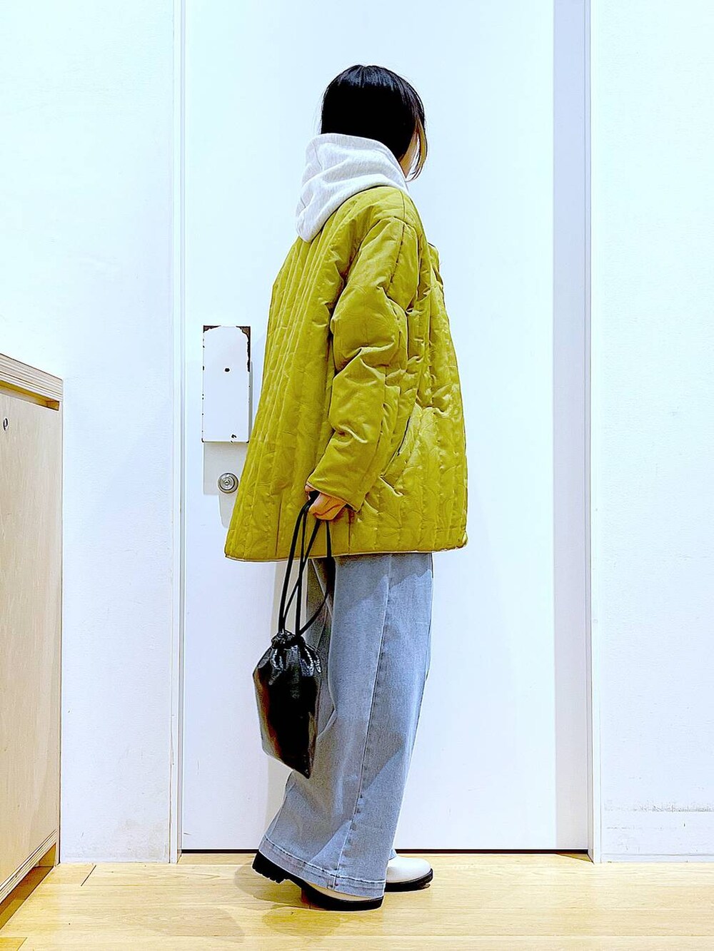 ブルー系のデニムパンツ、ベージュ系のブーツ、ベージュ系のパーカーを着用したレディースの冬コーディネートの4枚目の写真