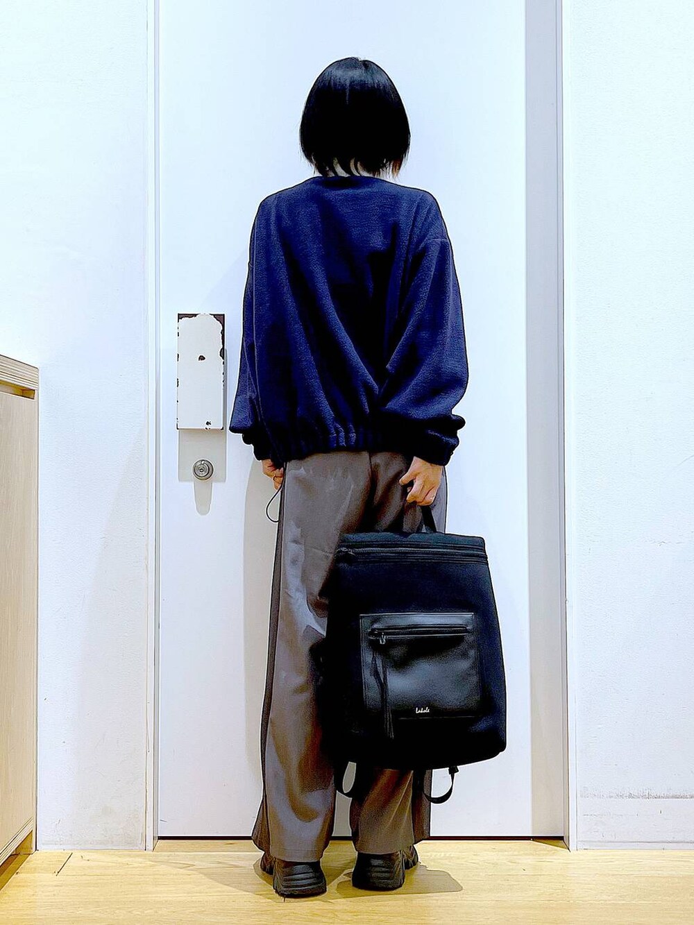 ブラック系のバックパック/リュック、ブラック系のブーツ、グレー系のその他パンツを着用したレディースの冬コーディネートの5枚目の写真