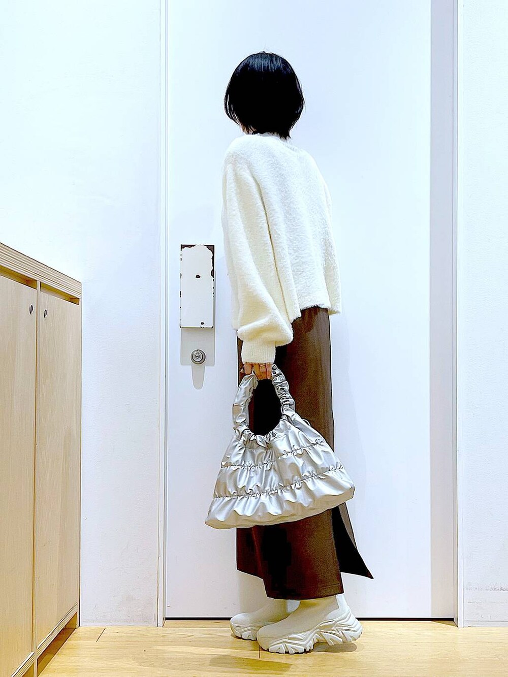 ベージュ系のニット/セーター、ベージュ系のブーツ、ブラウン系のサロペット/オーバーオールを着用したレディースの冬コーディネートの3枚目の写真