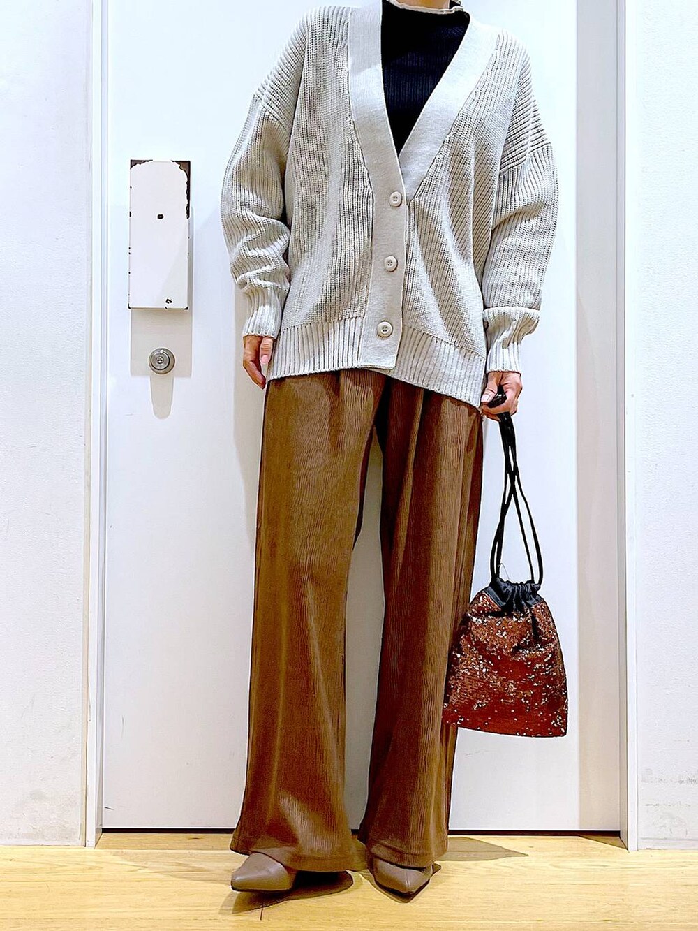 グレー系のカーディガン/ボレロ、ブラック系のニット/セーター、ブラウン系のショルダーバッグを着用したレディースの冬コーディネートの6枚目の写真