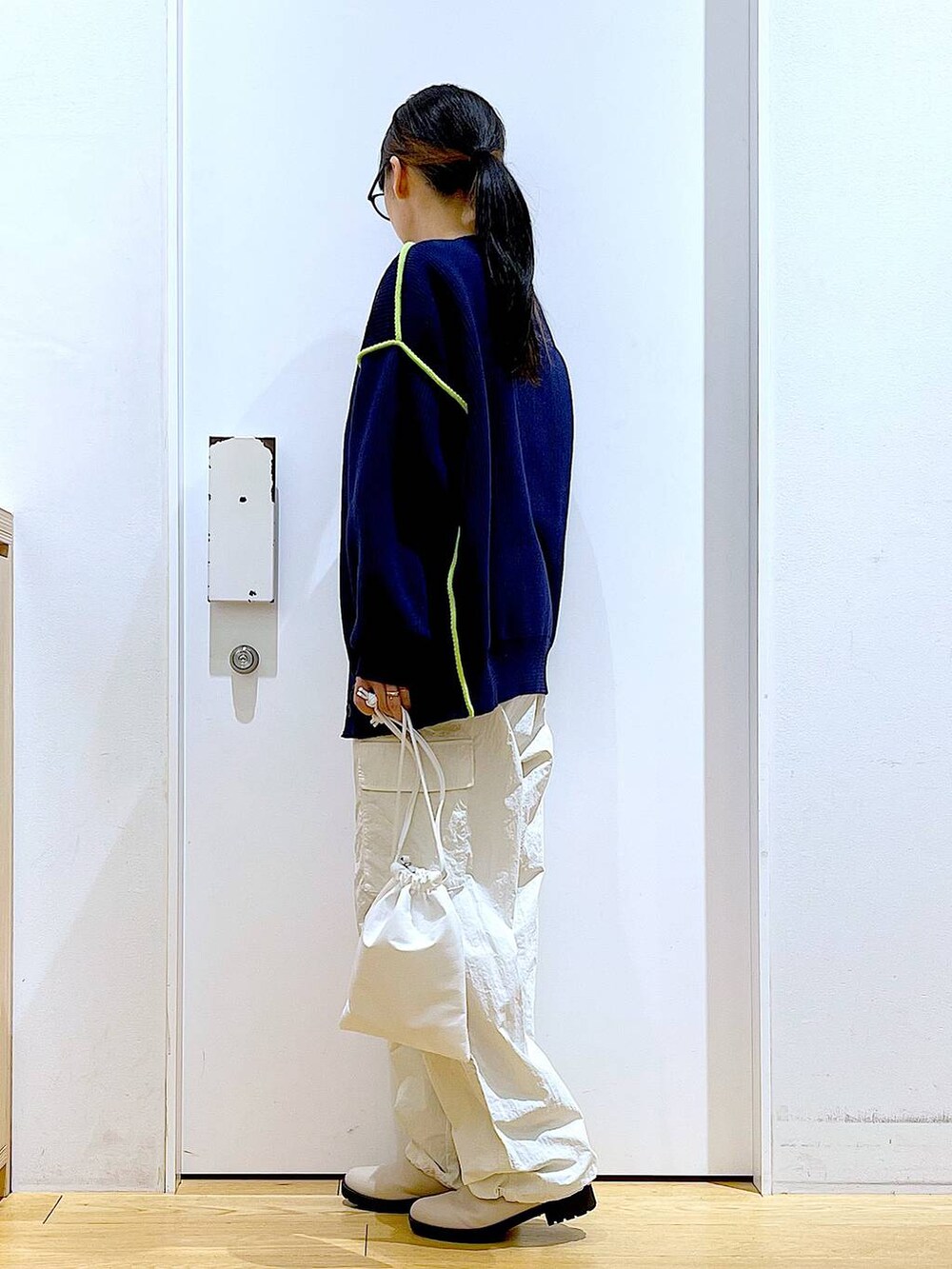 グレー系のTシャツ/カットソー、ベージュ系のブーツ、ホワイト系のショルダーバッグを着用したレディースの冬コーディネートの3枚目の写真