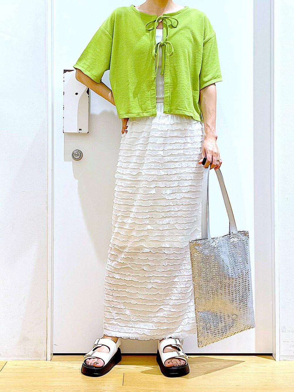 ホワイト系のサンダル、シルバー系のトートバッグ、ホワイト系のスカートを着用したレディースの秋コーディネートの6枚目の写真