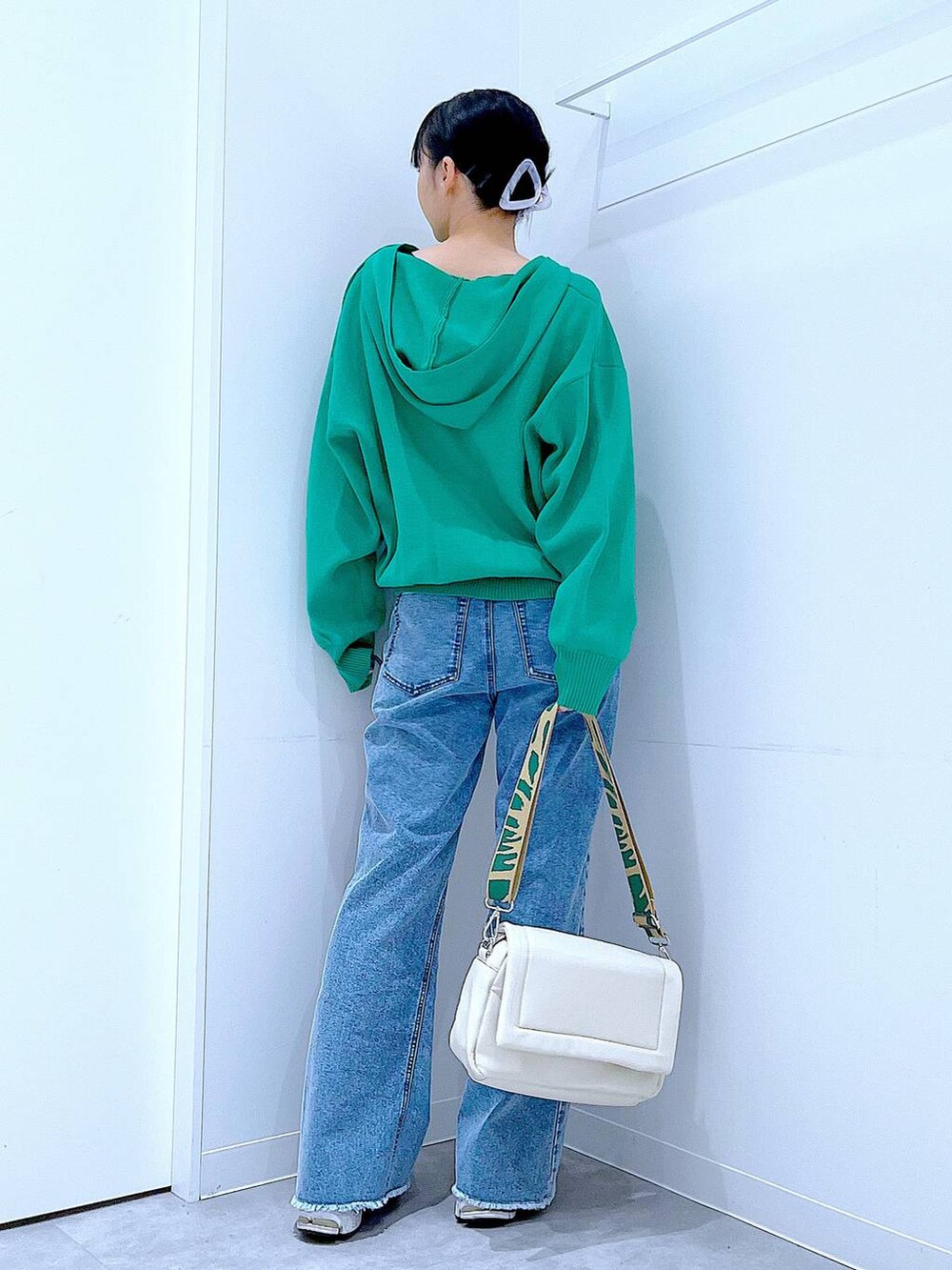 ホワイト系のショルダーバッグ、グリーン系のニット/セーター、ブルー系のデニムパンツを着用したレディースの春コーディネートの5枚目の写真