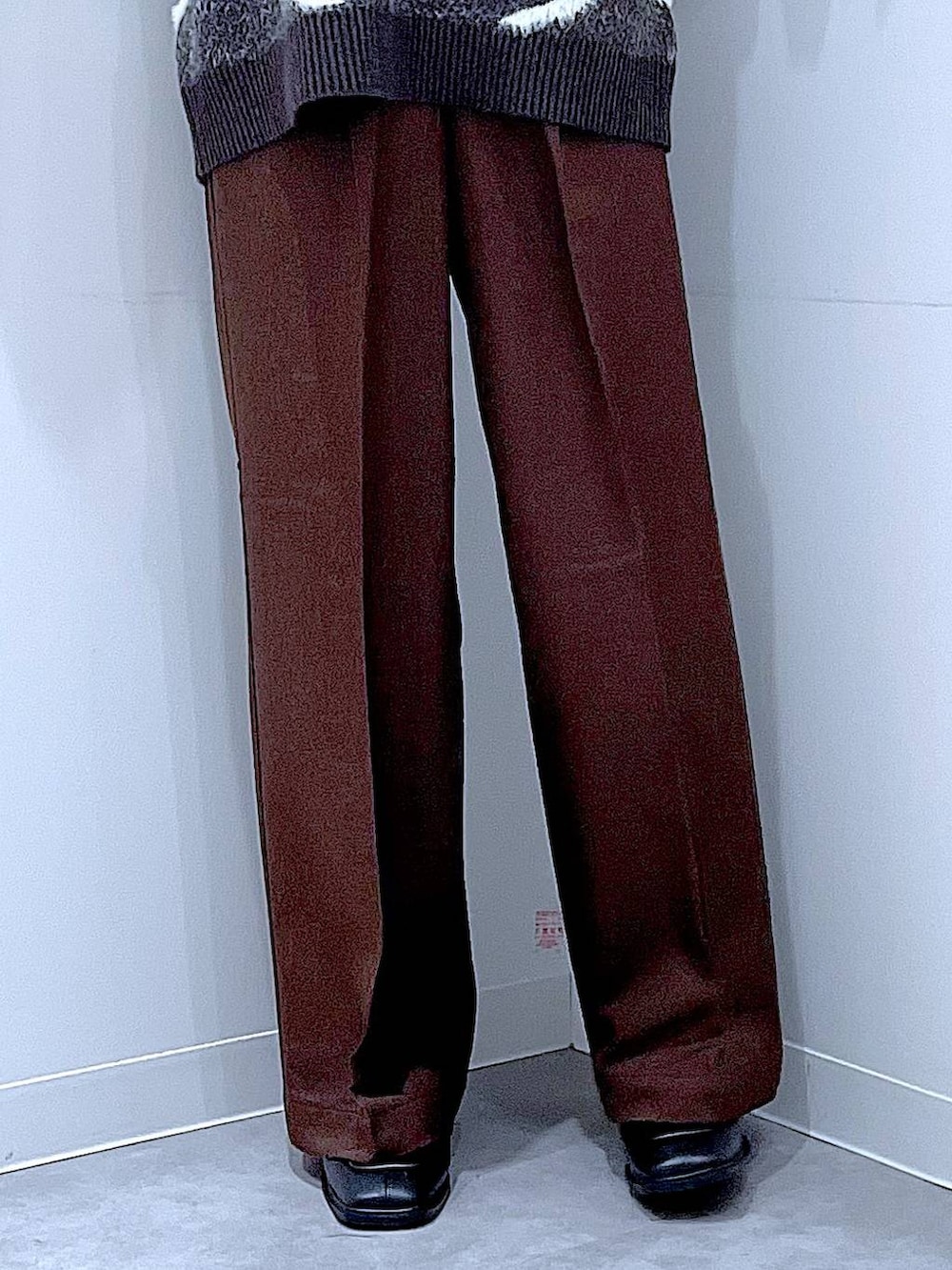 ブラック系のブーツ、ブラウン系のスラックス、ブラック系のショルダーバッグを着用したレディースの冬コーディネートの8枚目の写真