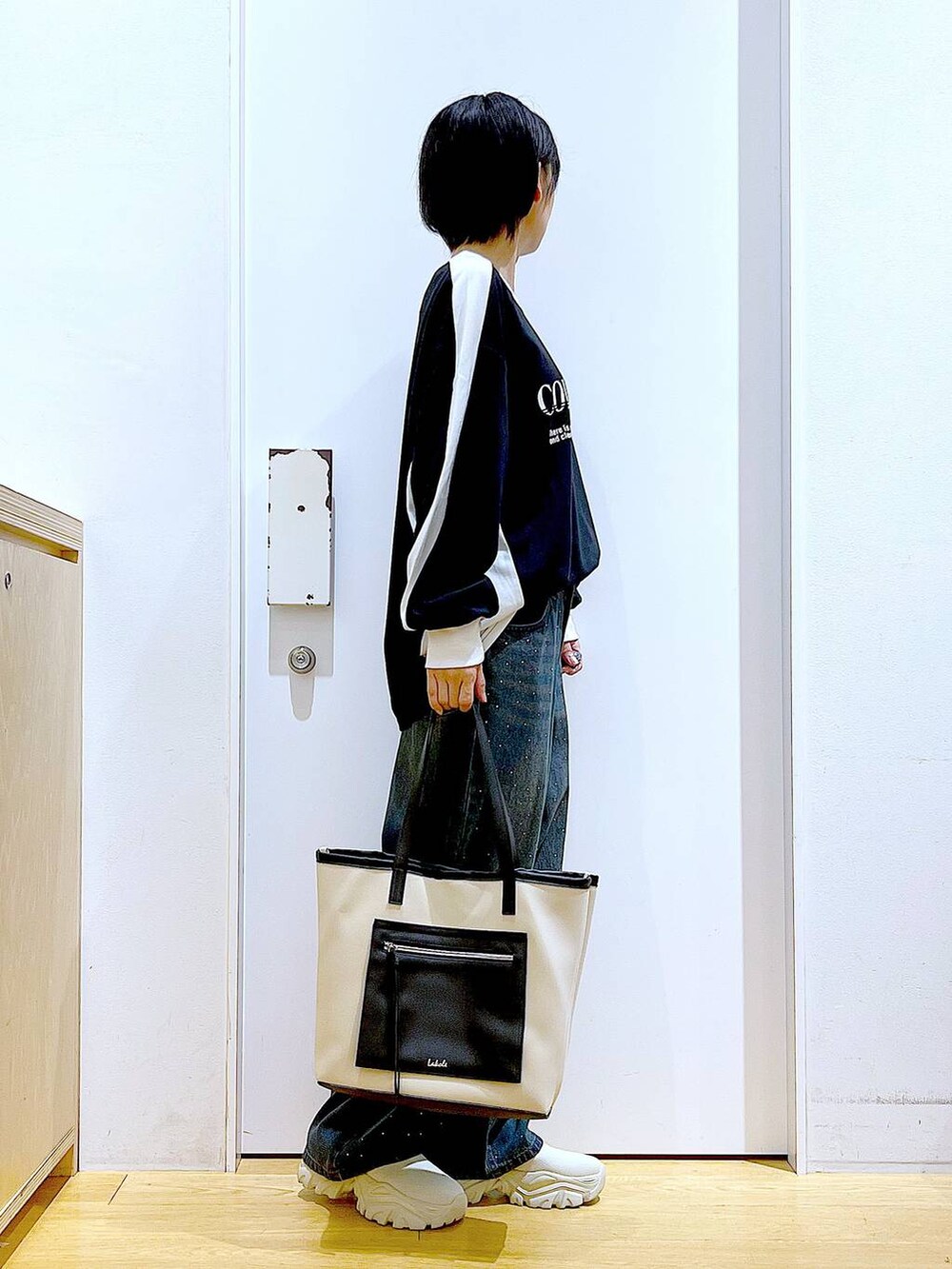 ベージュ系のブーツ、ホワイト系のトートバッグ、ブラック系のTシャツ/カットソーを着用したレディースの秋コーディネートの4枚目の写真