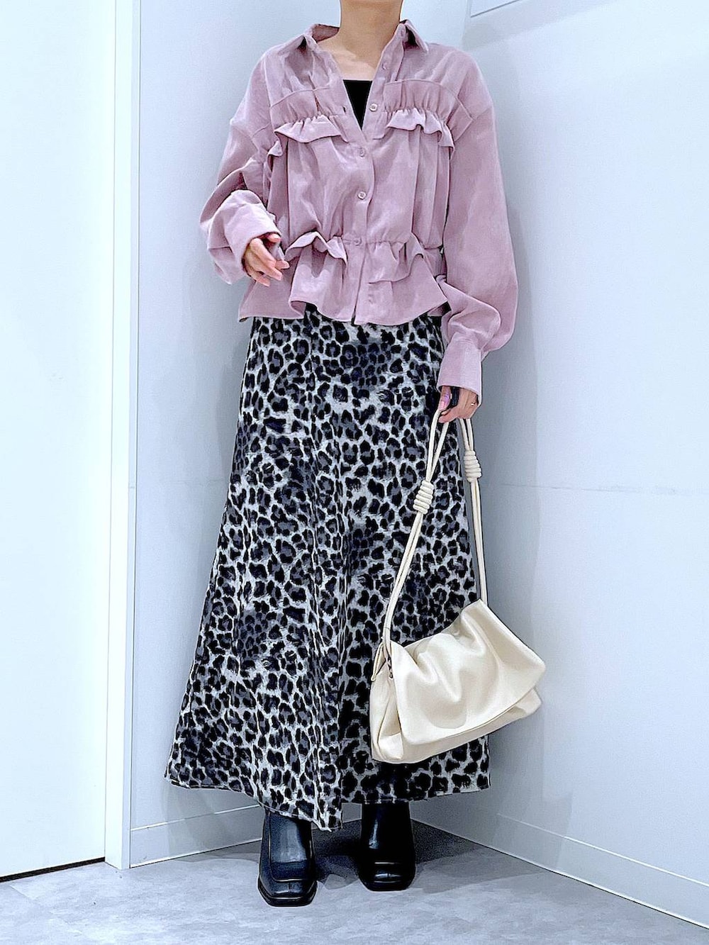 ホワイト系のショルダーバッグ、ブラック系のブーツ、グレー系のスカートを着用したレディースの秋コーディネートの6枚目の写真