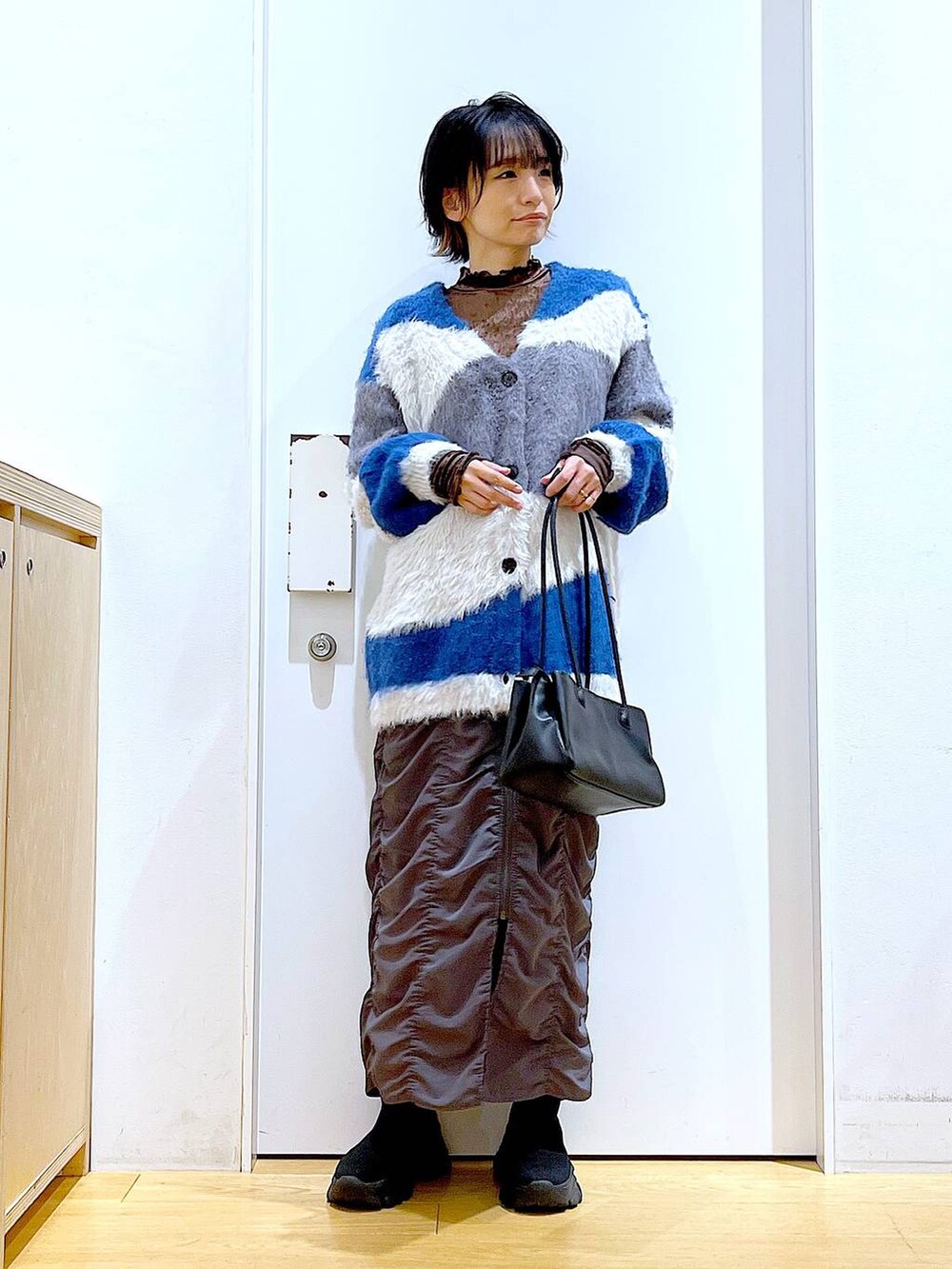 ブラック系のブーツ、ブラック系のトートバッグ、ブラウン系のTシャツ/カットソーを着用したレディースの秋コーディネートの2枚目の写真